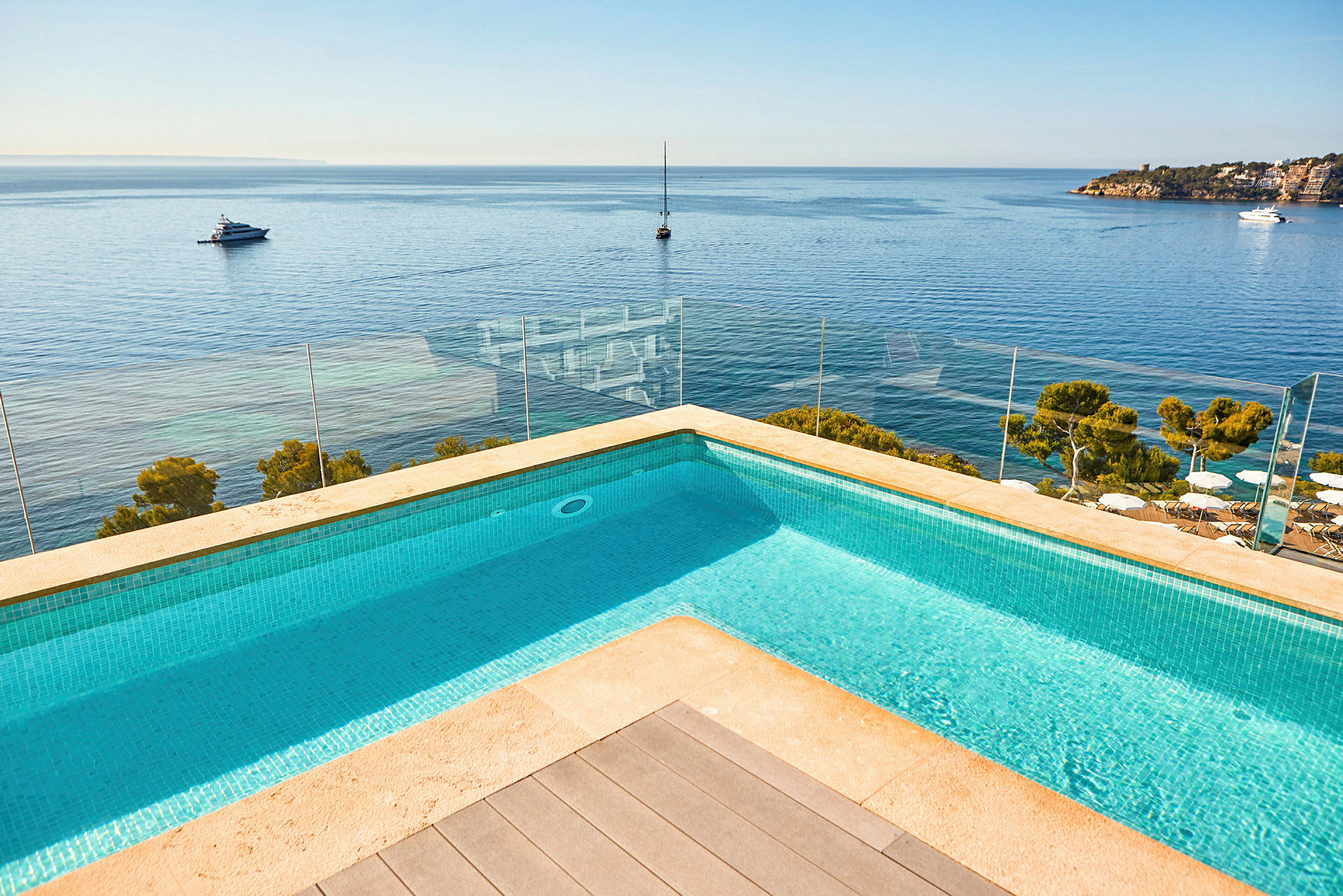 Billede af en pool med udsigt over havet og både. (AI-genereret tekst)