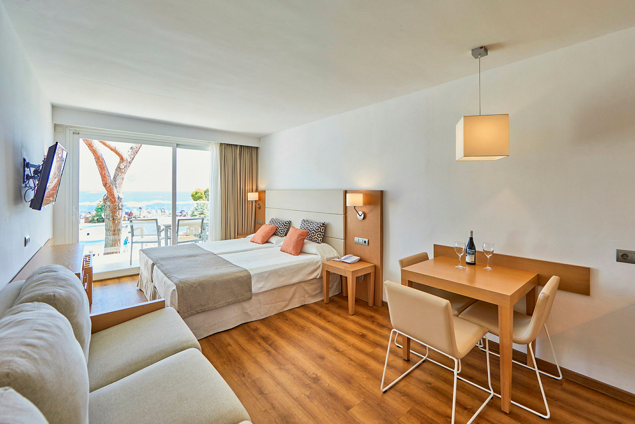 Hotelværelse med dobbeltseng, siddegruppe og spisebord med stole. (AI-genereret tekst)