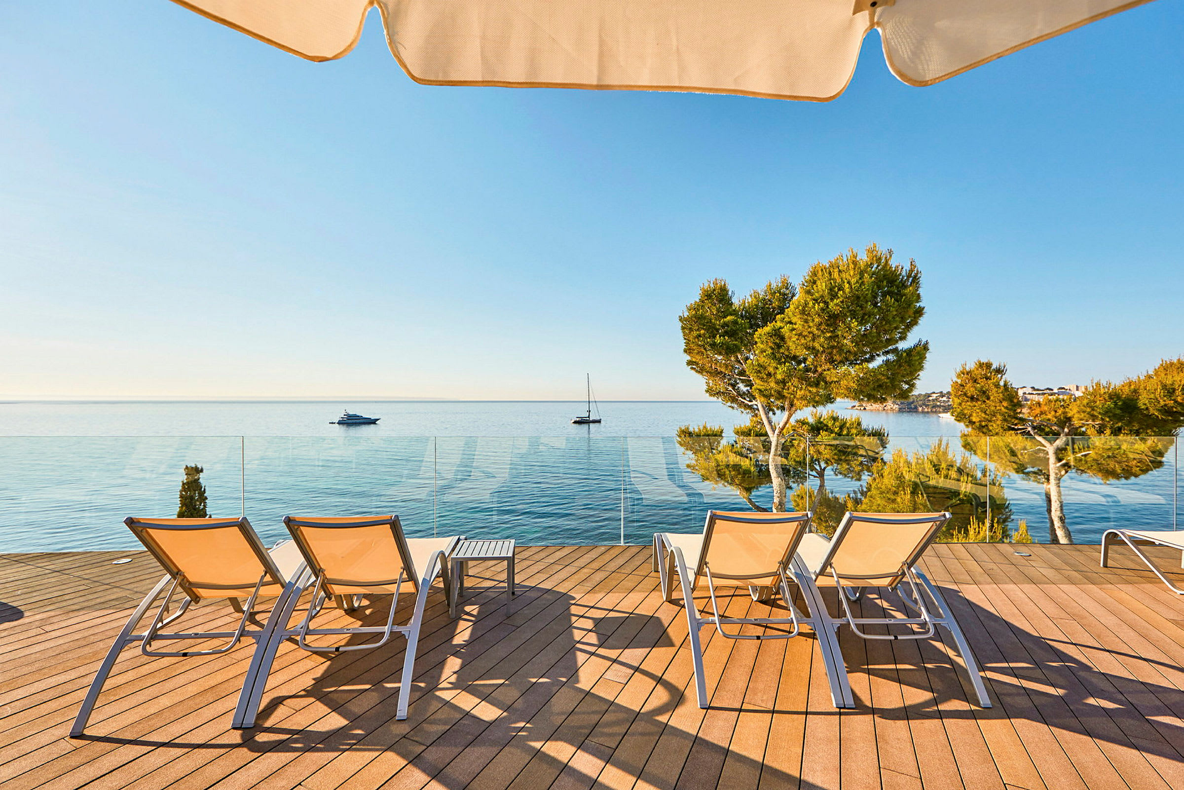 Liggestole på en terrasse med udsigt over havet. (AI-genereret tekst)