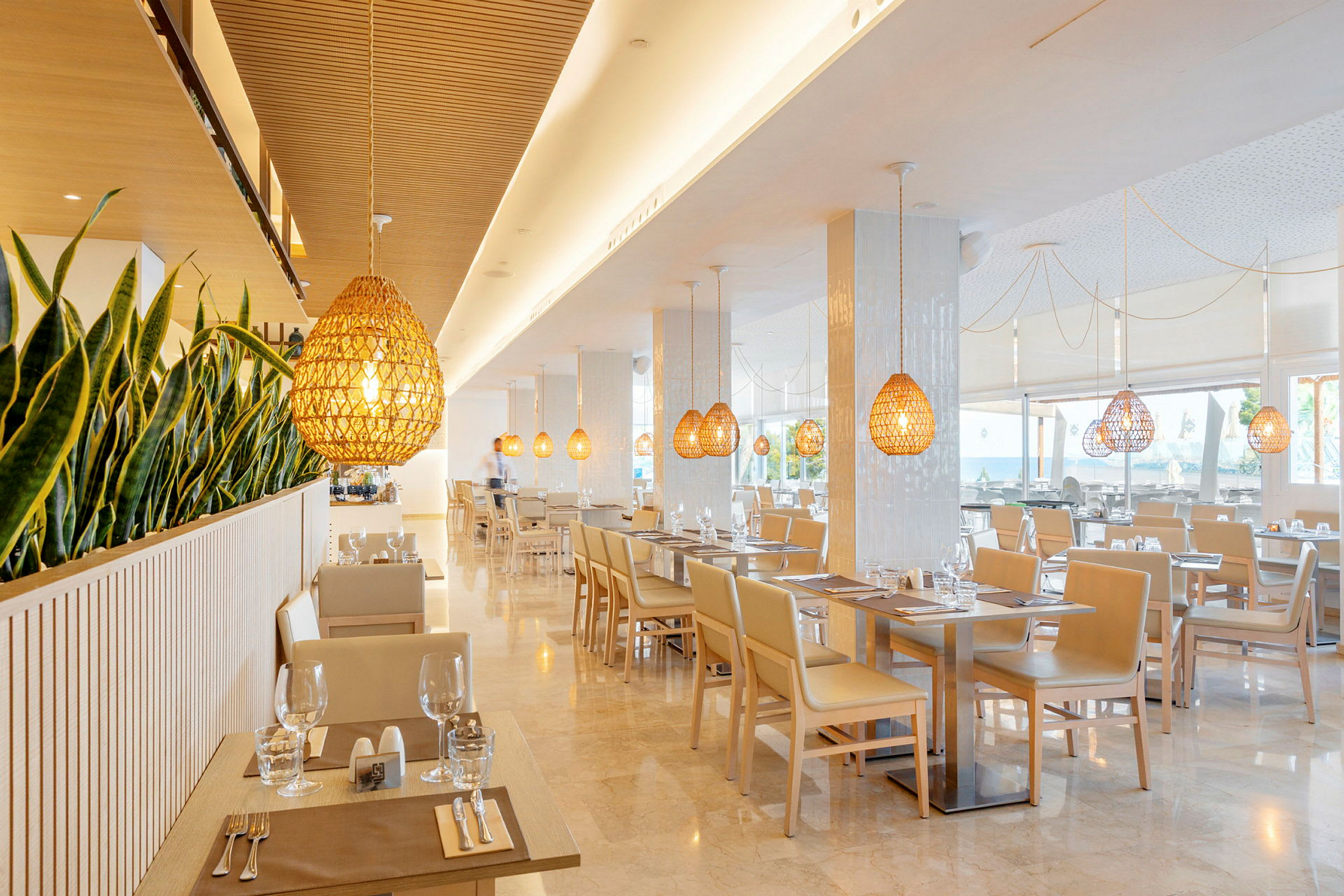 En moderne og lys restaurant med planter som skillefunktion og hængende lamper i trædesign. (AI-genereret tekst)