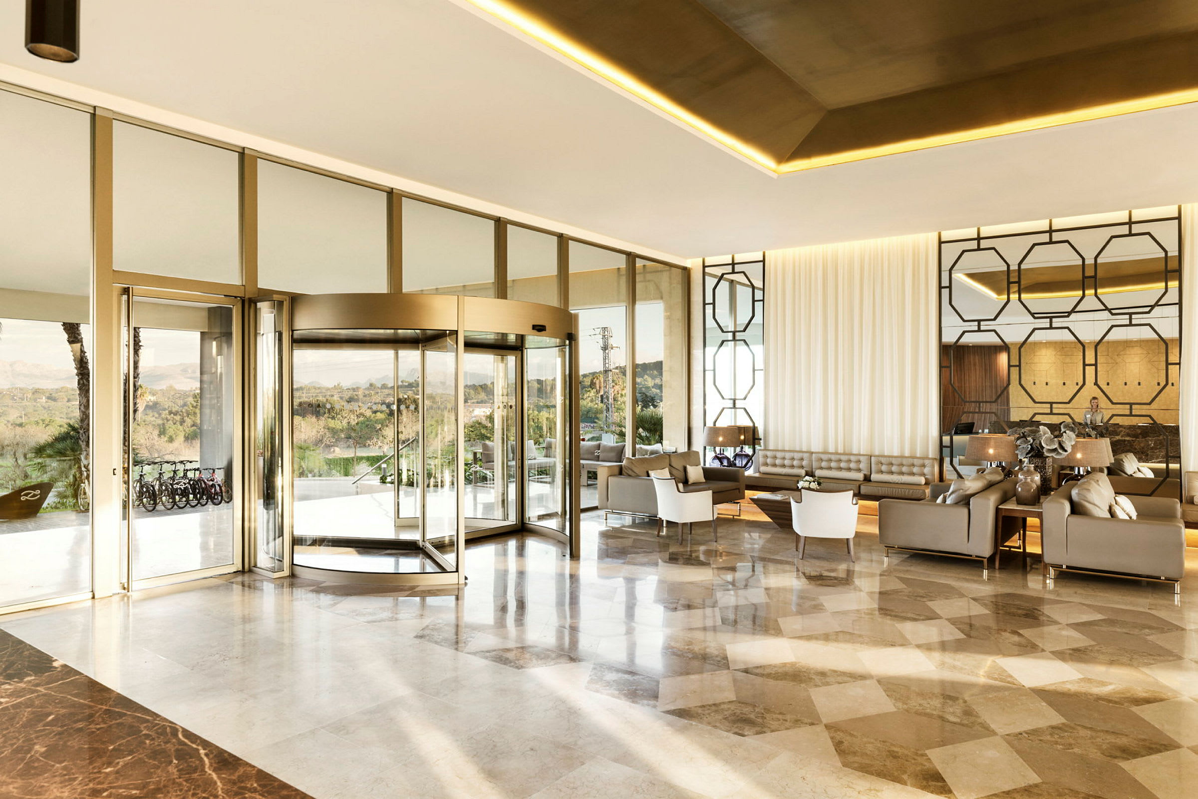 En moderne hotellobby med en glasvæg og karruseldør. (AI-genereret tekst)
