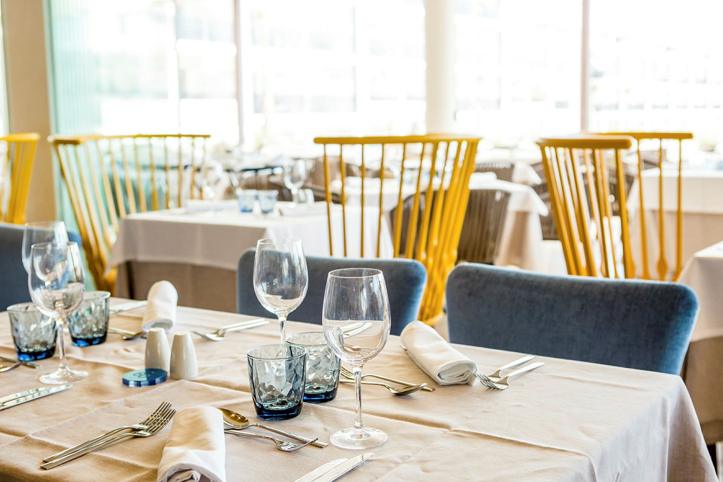 Indrettet restaurant med dækkede borde og stole. (AI-genereret tekst)