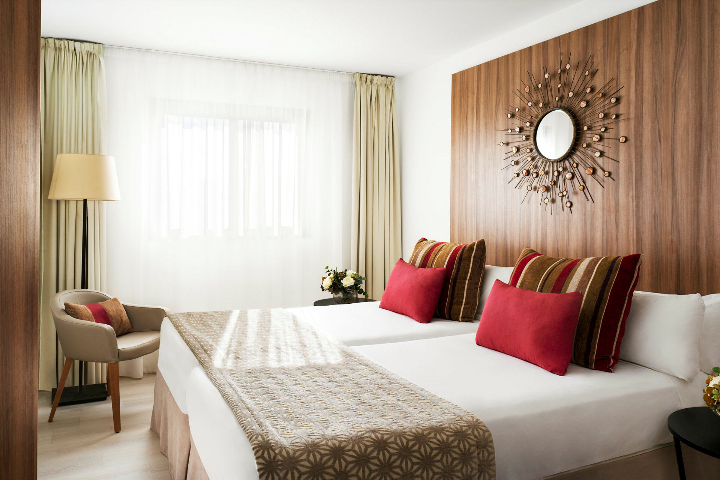 Moderne hotelværelse med to senge, farverige puder og minimalistisk indretning. (AI-genereret tekst)