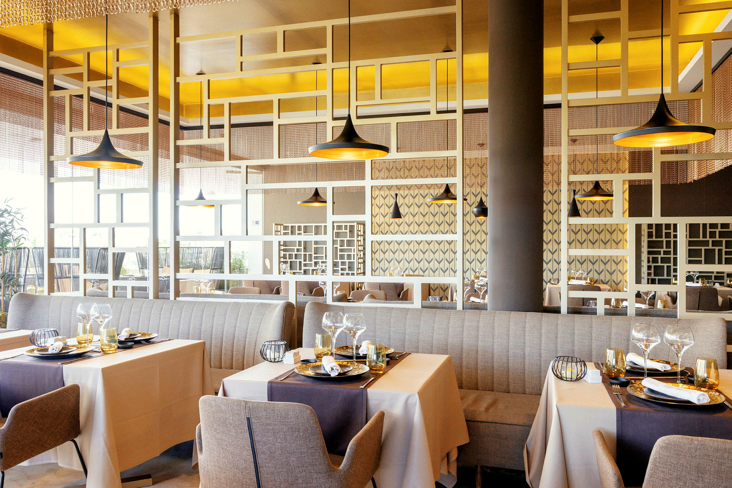Billede af en elegant restaurant med borde dækket til måltider og moderne dekorative detaljer. (AI-genereret tekst)