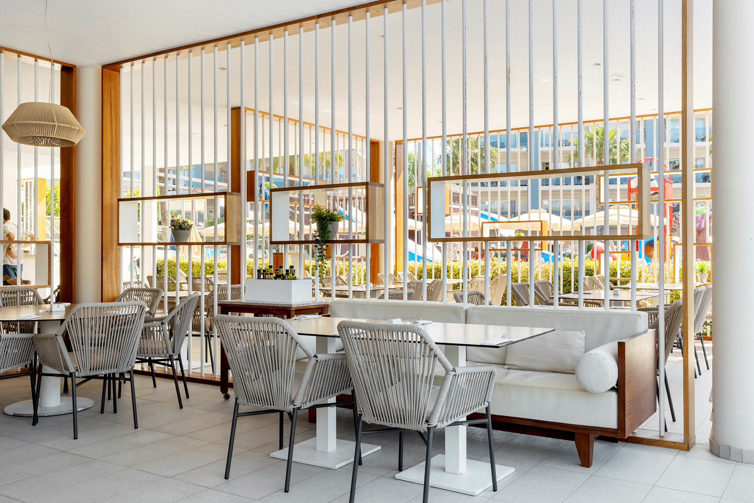 En udendørsrestaurant med borde og stole og en moderne indretning. (AI-genereret tekst)