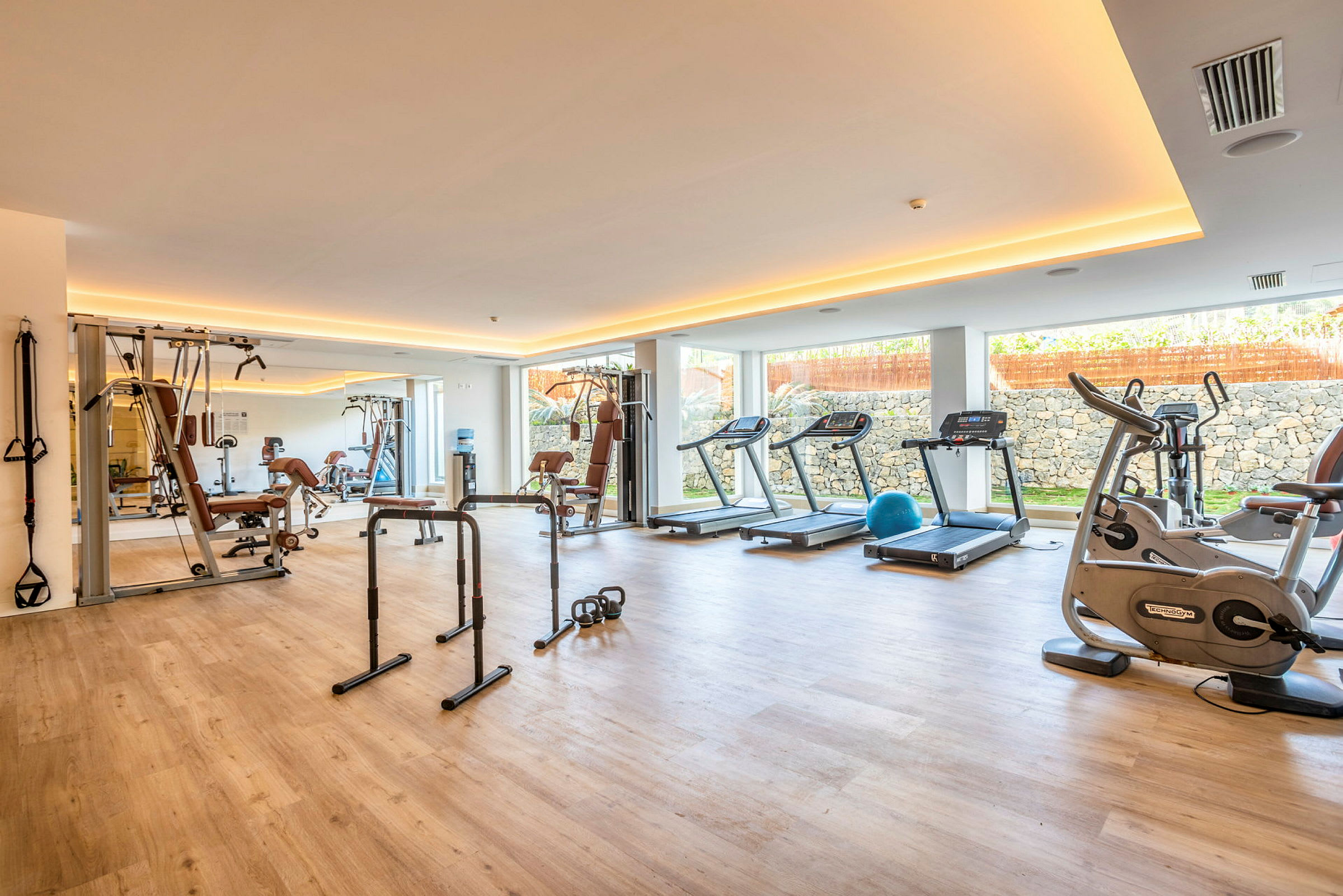 Fitnesscenter med træningsudstyr såsom løbebånd og styrketræningsmaskiner. (AI-genereret tekst)