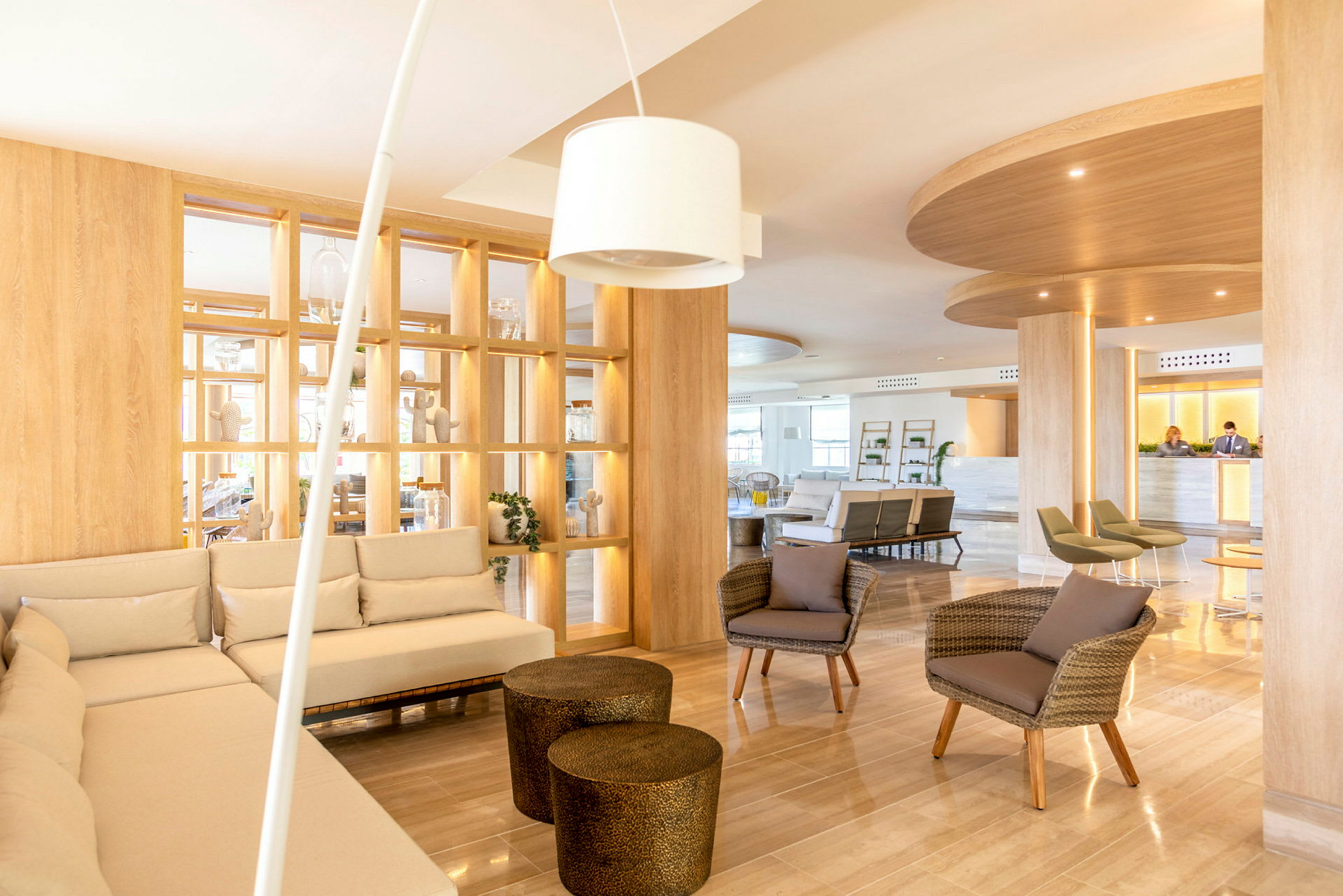 Et lyst og moderne hotel-lobbyområde med sofaer, lænestole og dekorative hylder. (AI-genereret tekst)