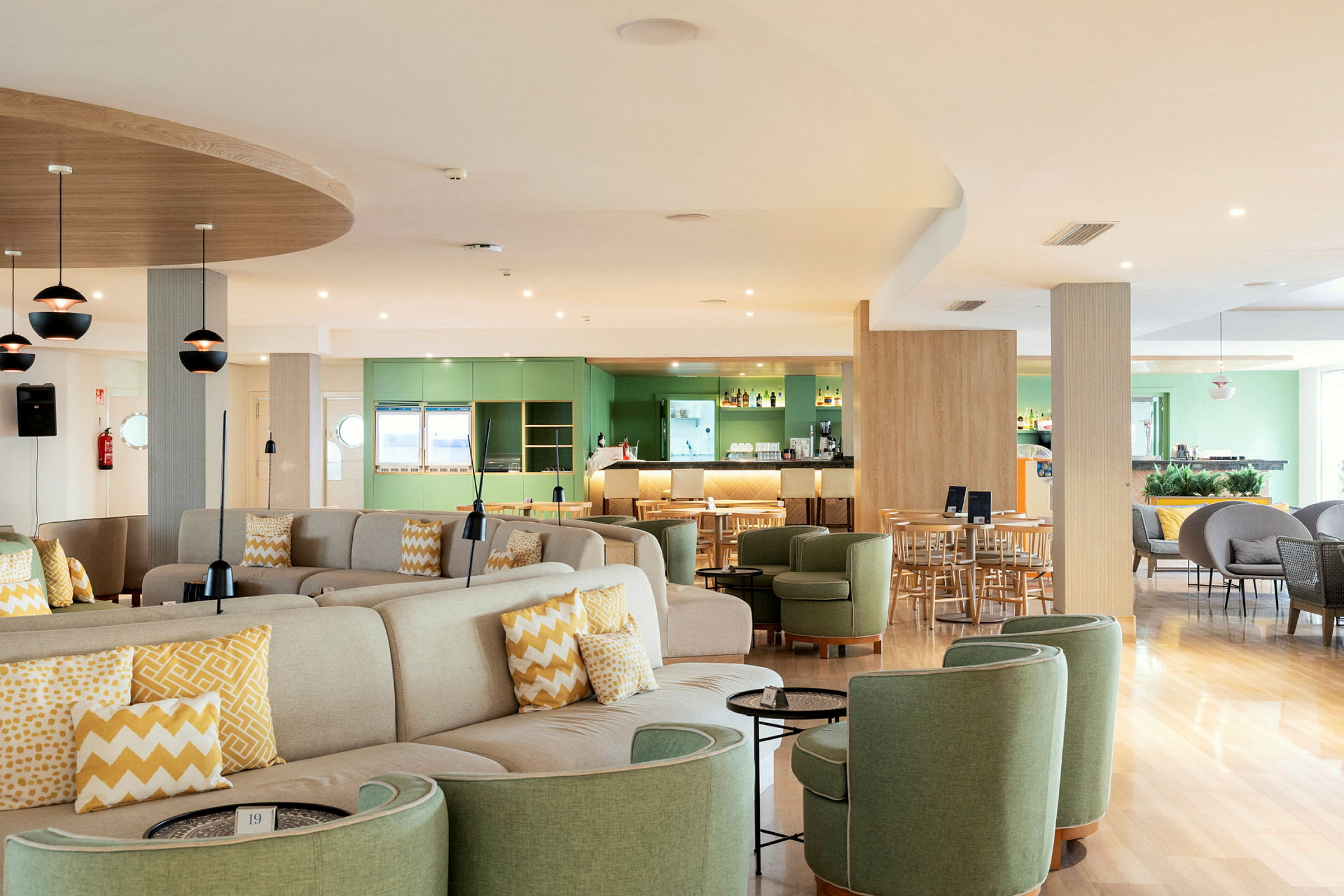 Restaurant med siddegrupper og barområde, lyse farver og moderne indretning. (AI-genereret tekst)