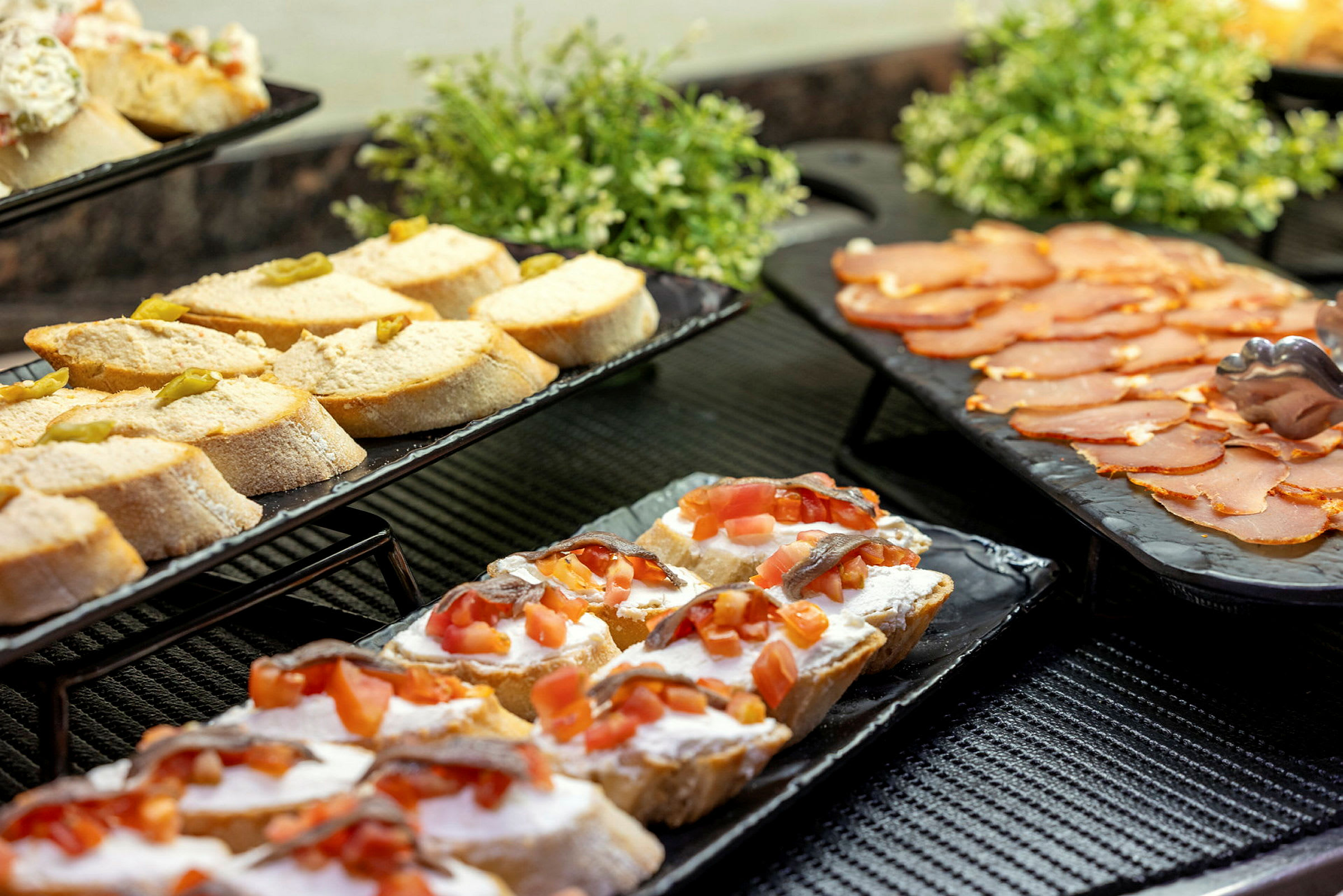 Sandwiches anrettet på fade sammen med pålæg på et bord. (AI-genereret tekst)