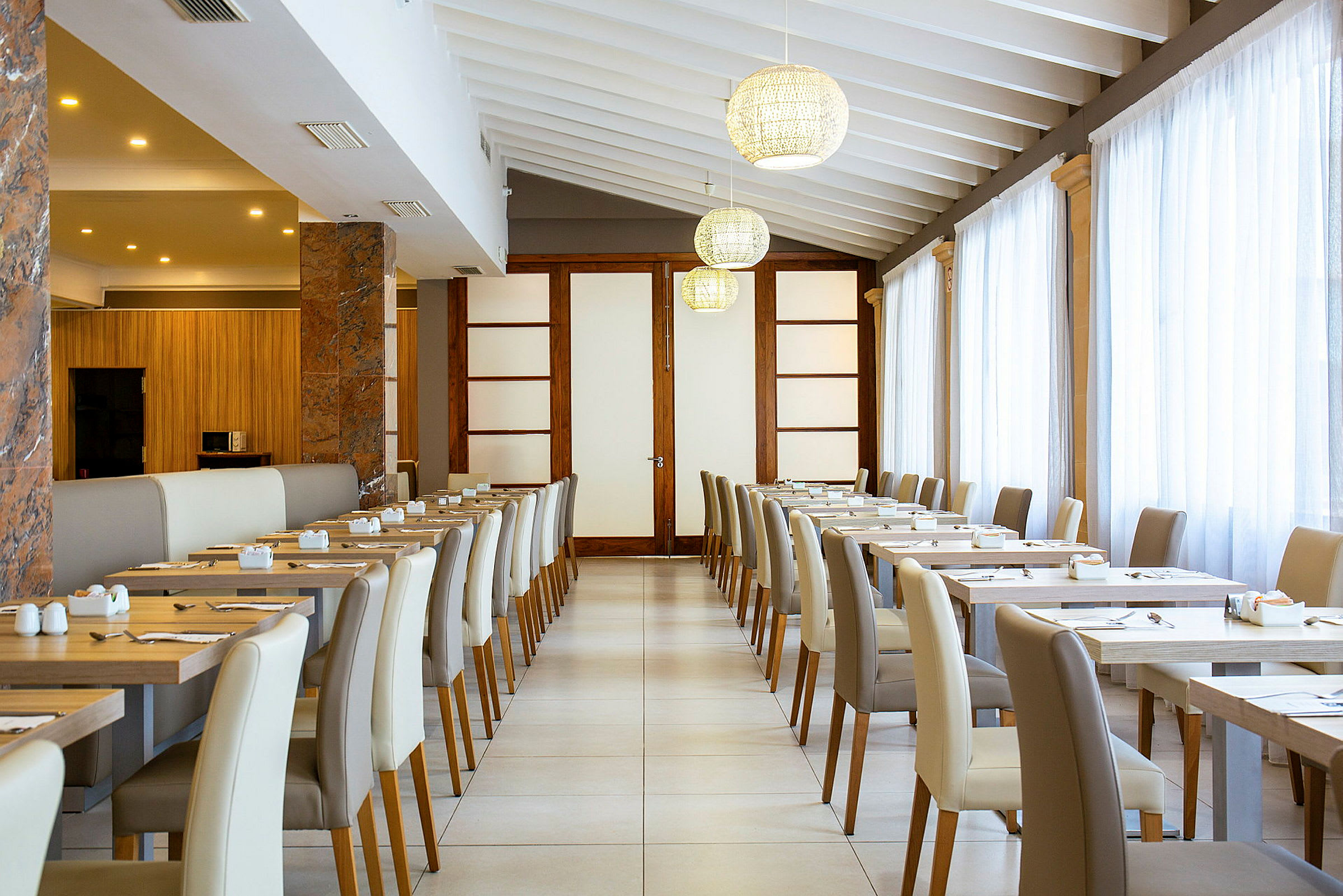Indretning af en lys restaurant med dækkede borde og stole. (AI-genereret tekst)