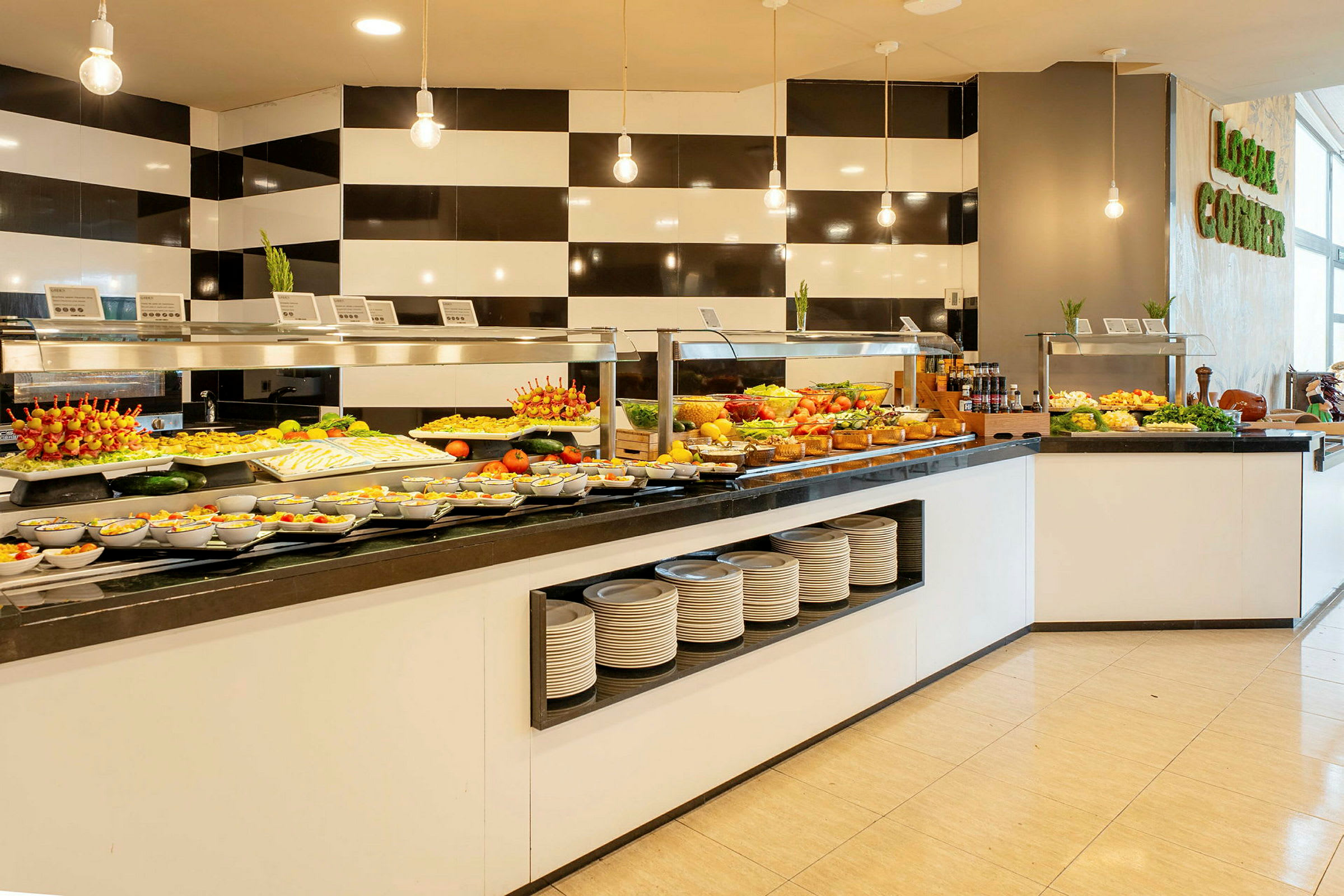 En buffet med forskellige retter og salater, arrangeret på et bord med sort kant. Mad er organiseret i skåle og fade. (AI-genereret tekst)