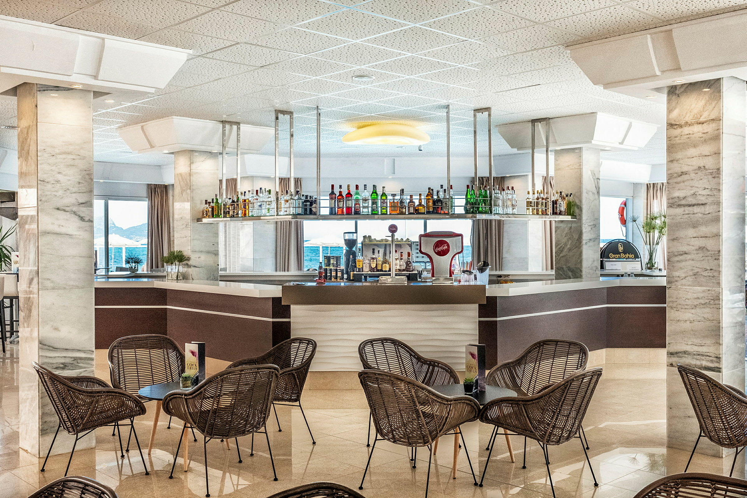 Hotelbar med stole og borde i forgrunden. (AI-genereret tekst)