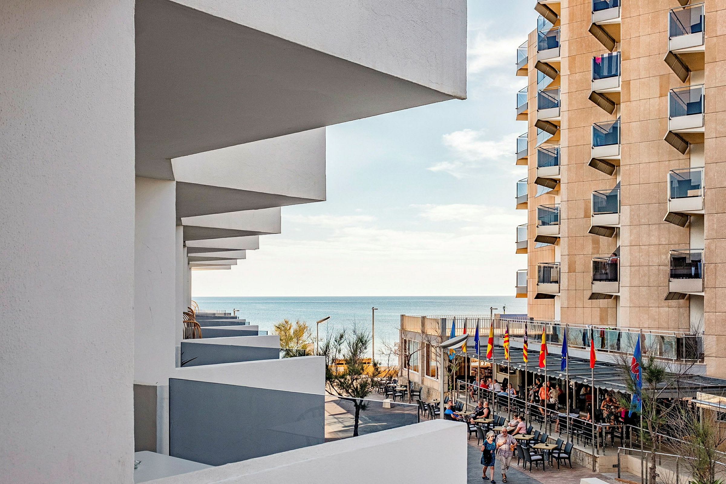 En udsigt over havet set fra et hotel med terrasser og altaner på bygningen. (AI-genereret tekst)