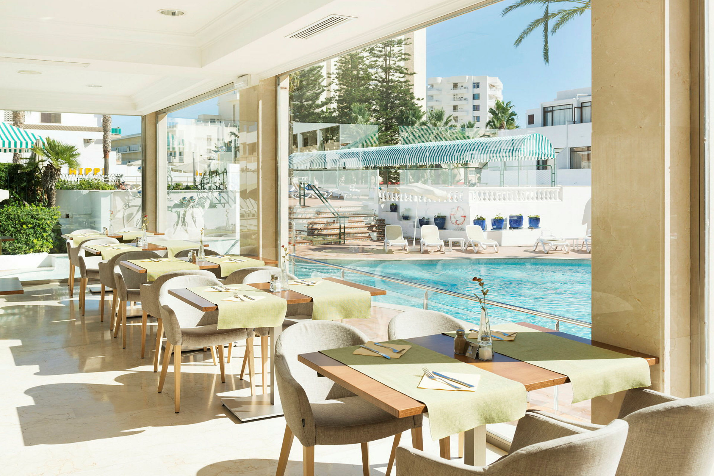En restaurant med udsigt over en pool og liggestole. (AI-genereret tekst)