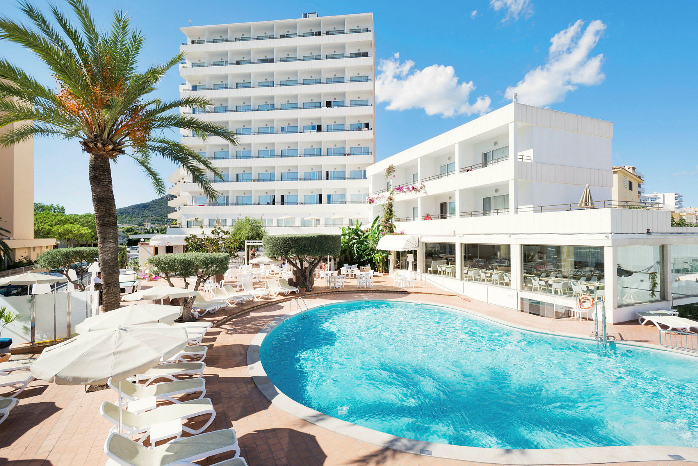 Hotel med pool og liggestole. (AI-genereret tekst)