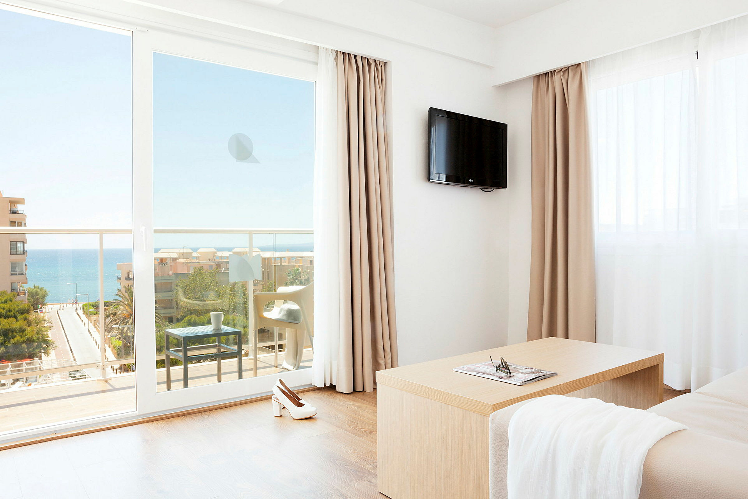 Et hotelværelse med udsigt til havet gennem en balkon. (AI-genereret tekst)
