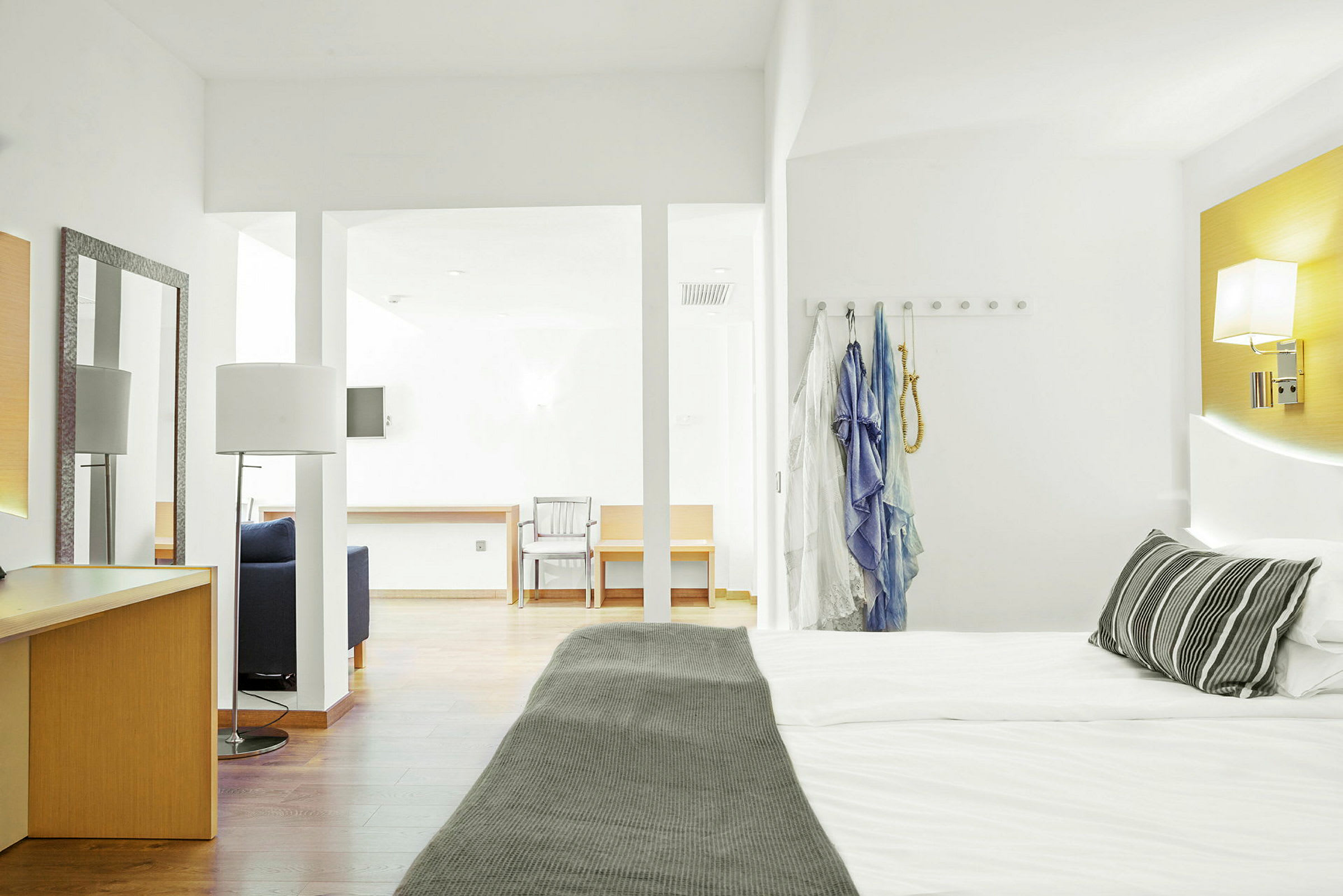 Hotelværelse med en dobbeltseng, skrivebord og siddepladser. (AI-genereret tekst)