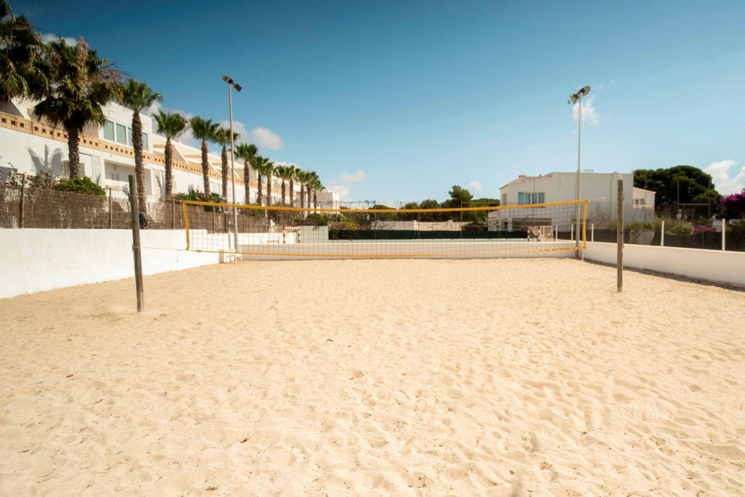 Sandbane med et volleyballnet udendørs. (AI-genereret tekst)