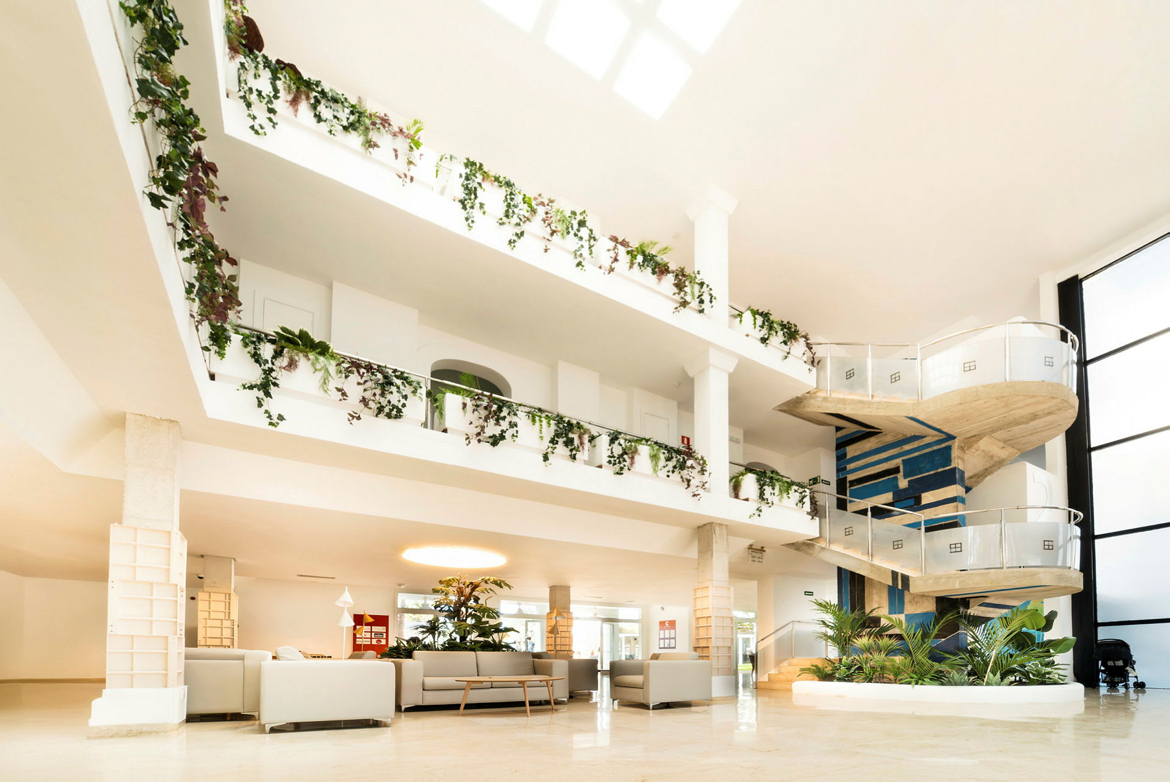 Indretning af rummeligt hotel med en spiraltrappe og frodige dekorationer. (AI-genereret tekst)