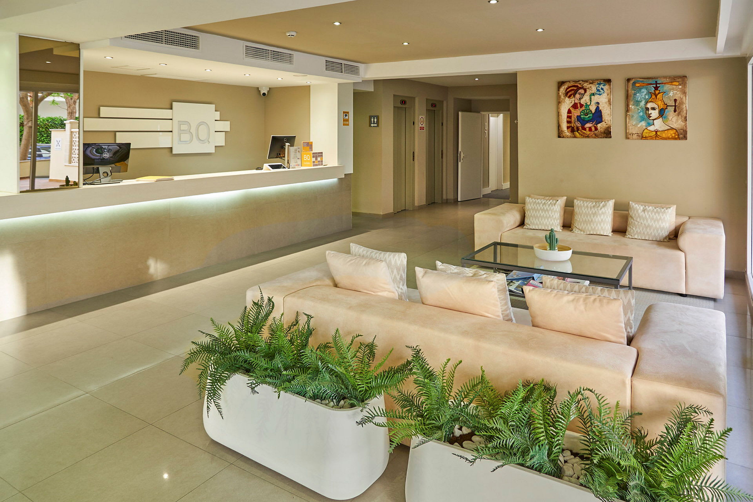 Hotellets lobby med reception, sofaer og plantepynt. (AI-genereret tekst)