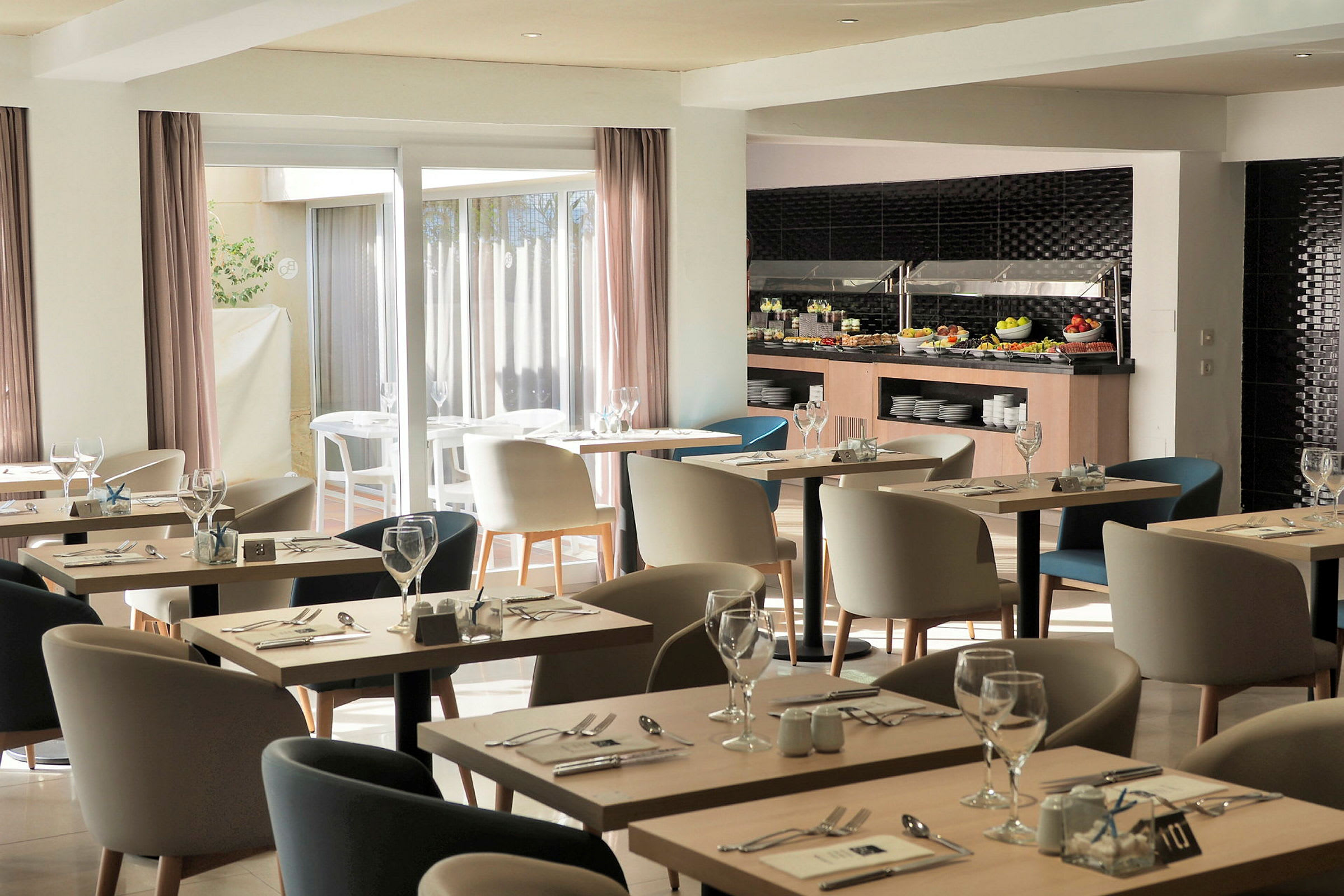 Billedet viser en moderne restaurant med borde og stole samt en buffet med mad. (AI-genereret tekst)