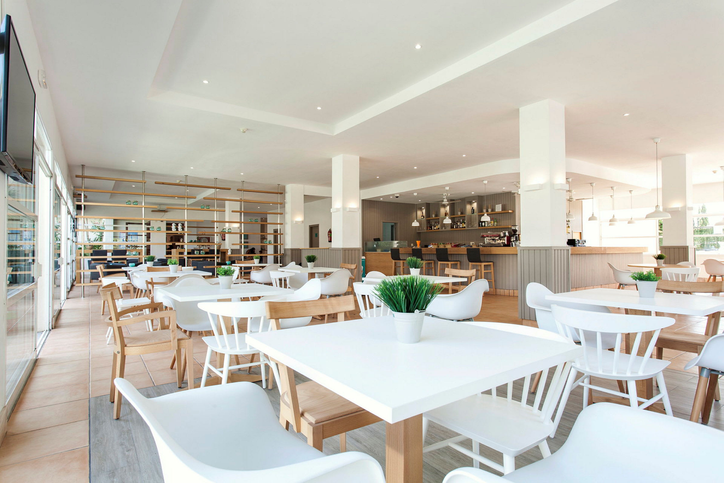 En moderne restaurant med hvide møbler og trædetaljer. (AI-genereret tekst)