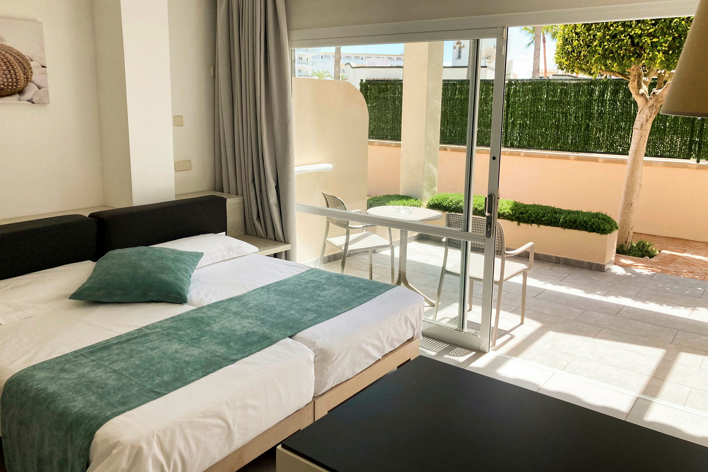 Moderne indrettet hotelværelse med seng og udsigt til en privat terrasse. (AI-genereret tekst)