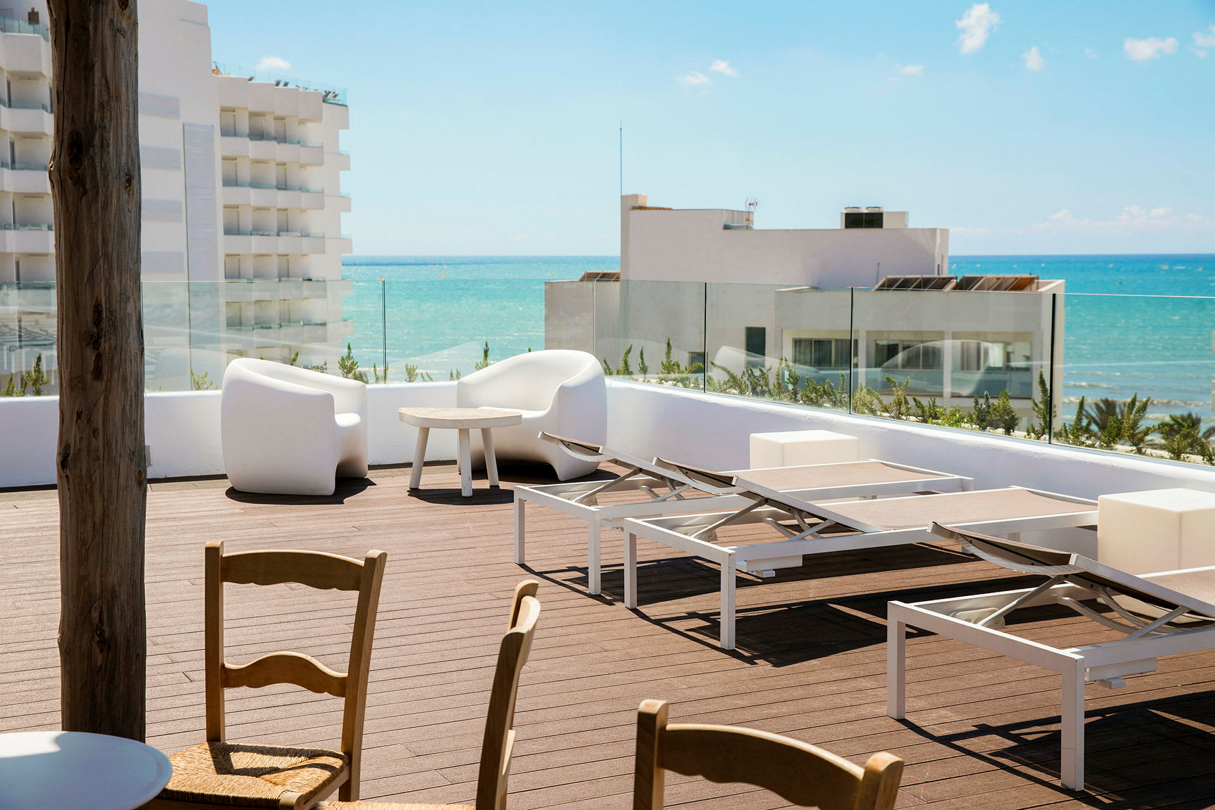 En solterrasse med solsenge og siddeområde, med udsigt over havet. (AI-genereret tekst)