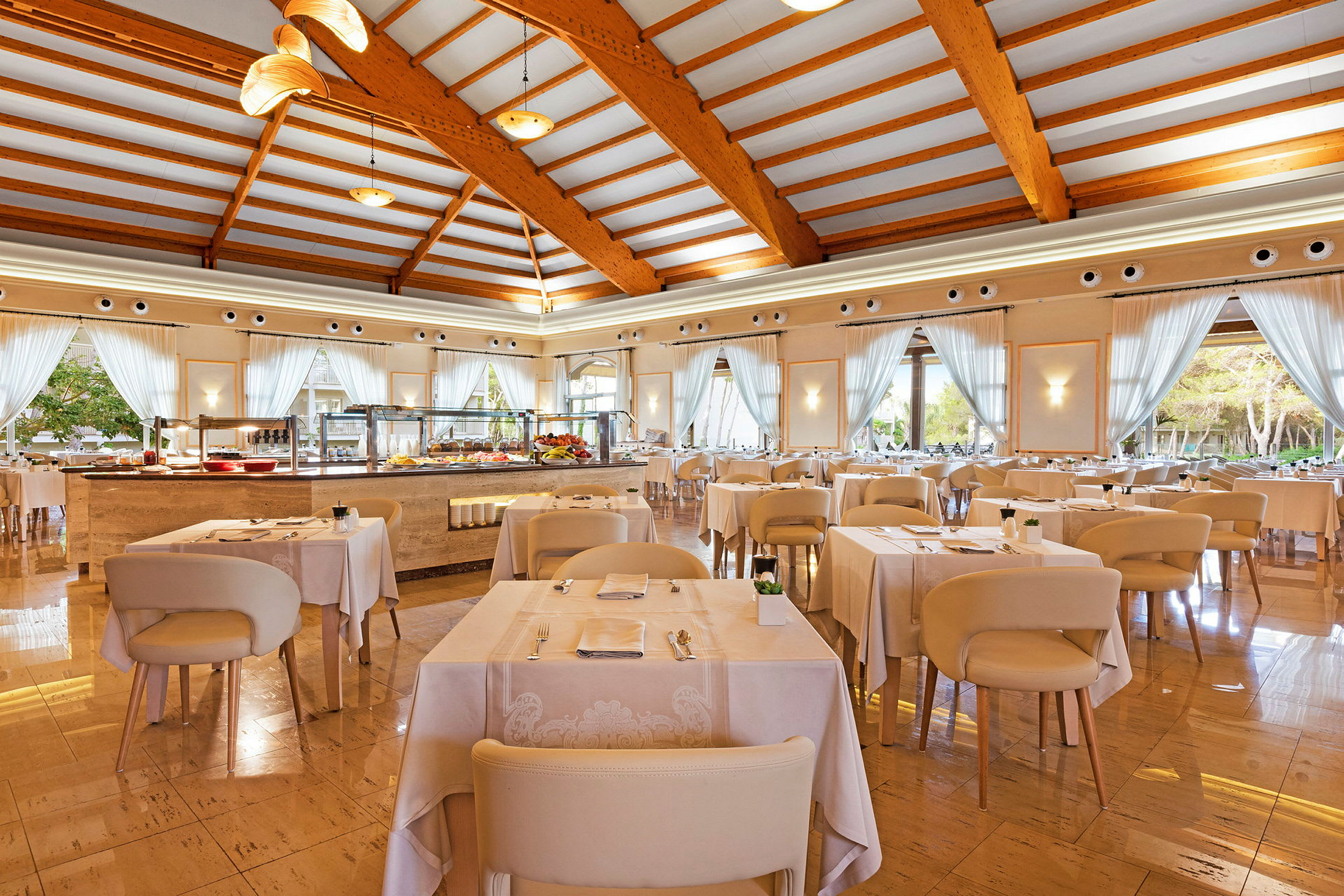 En lys restaurant med dækkede borde og store vinduer. (AI-genereret tekst)