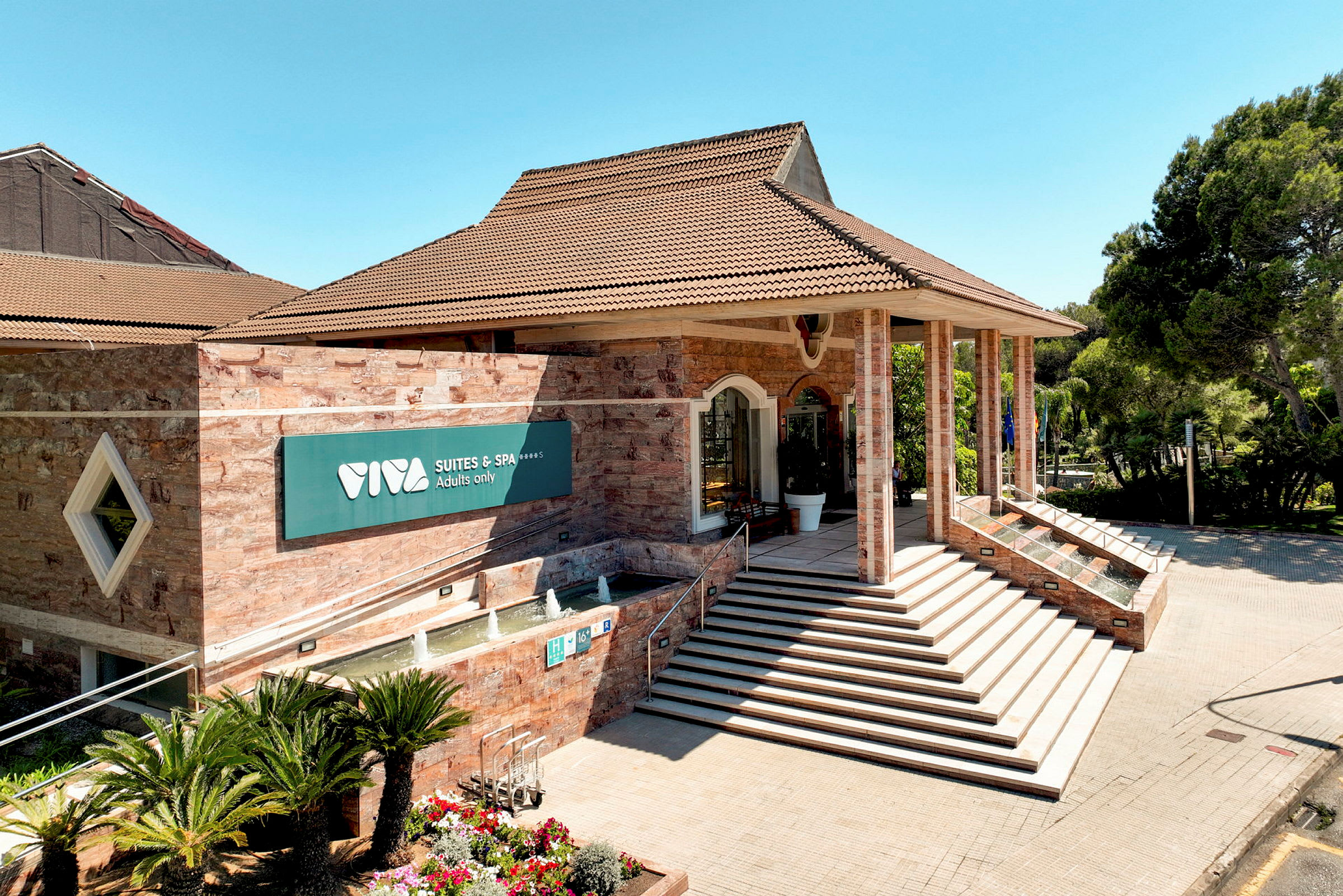 Indgang til Viva Suites & Spa med trapper og springvand. (AI-genereret tekst)