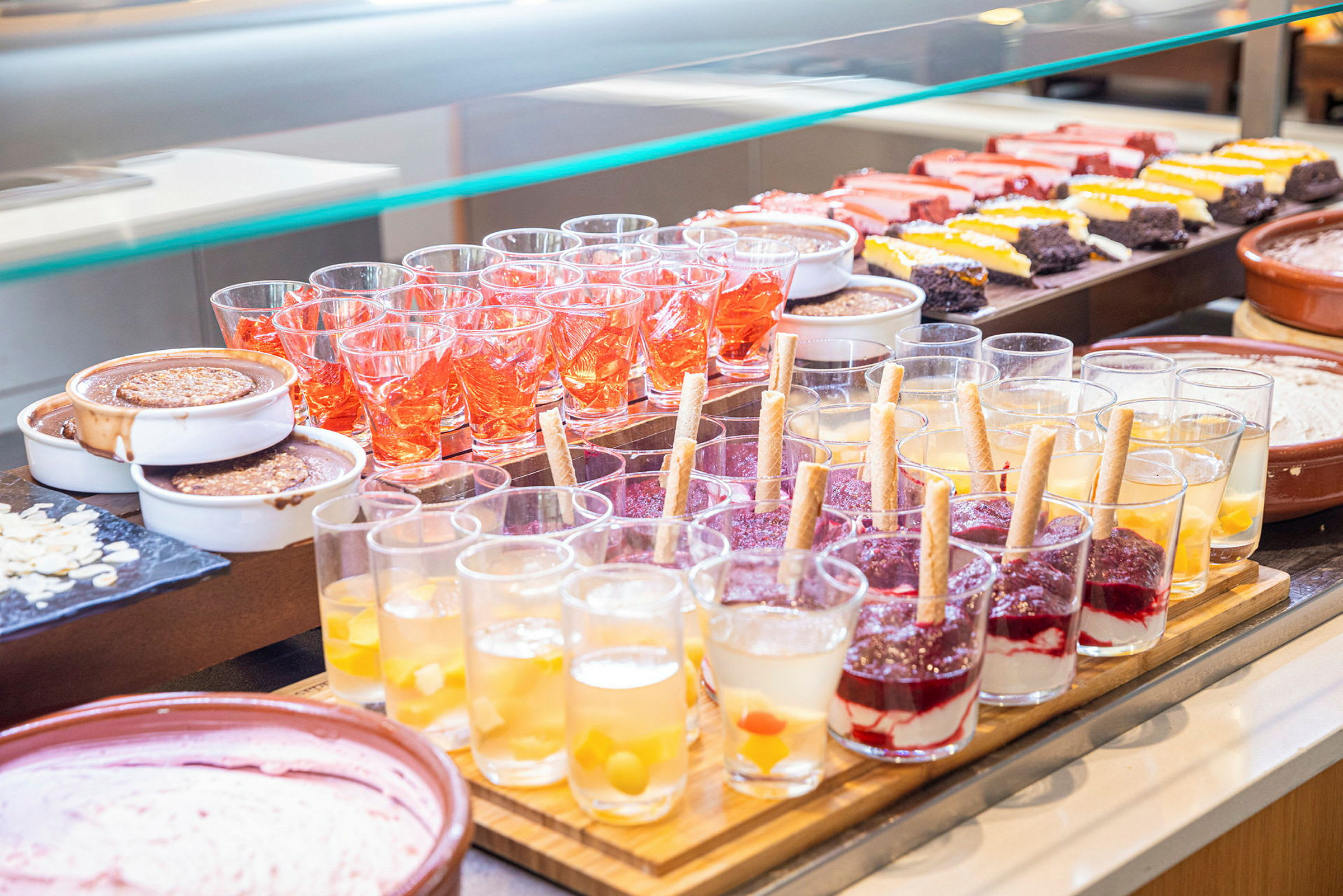 En buffet med forskellige desserter, såsom glas med gelé og fløde, samt kager. (AI-genereret tekst)