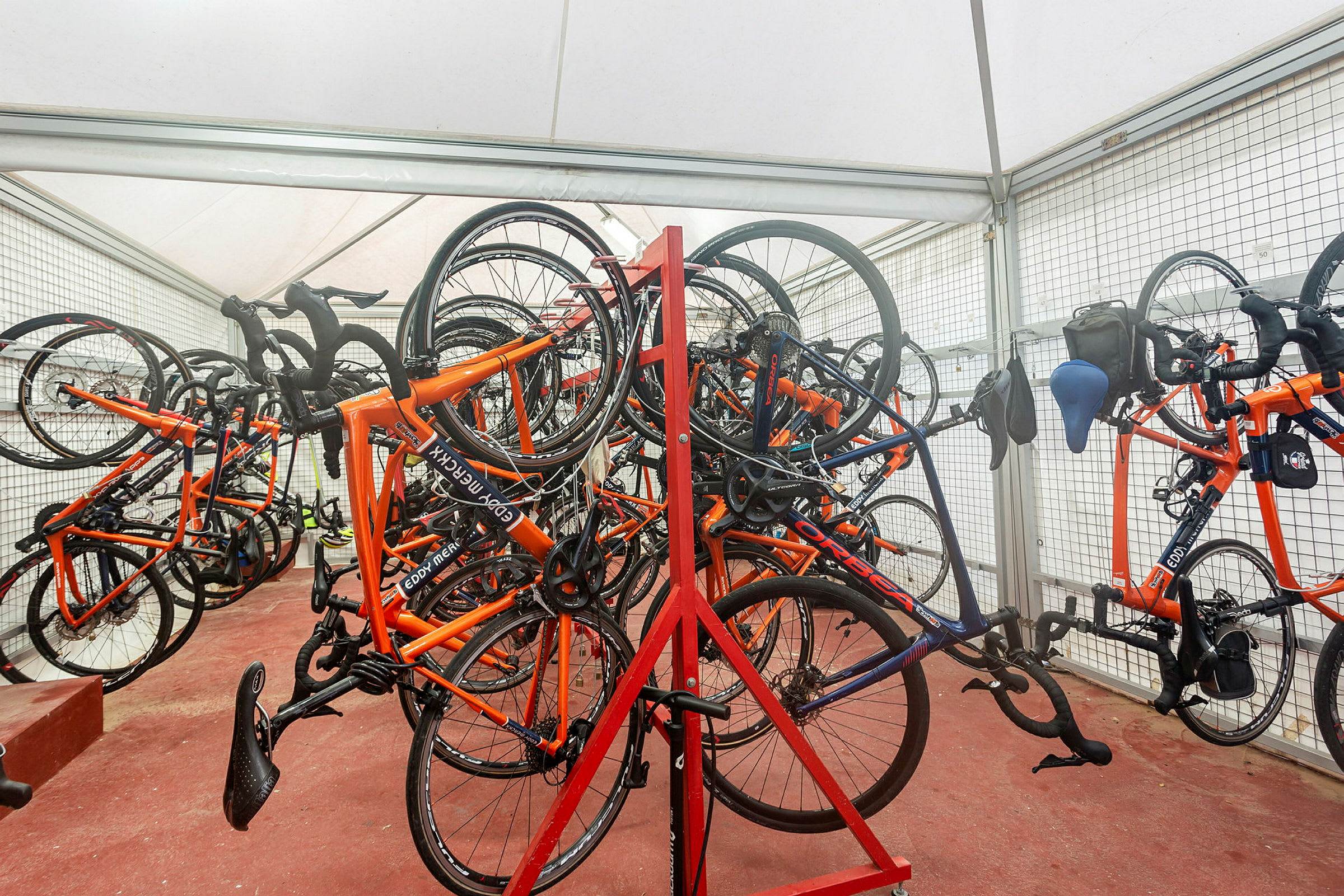 Cykler hængende på stativer i et telt. (AI-genereret tekst)