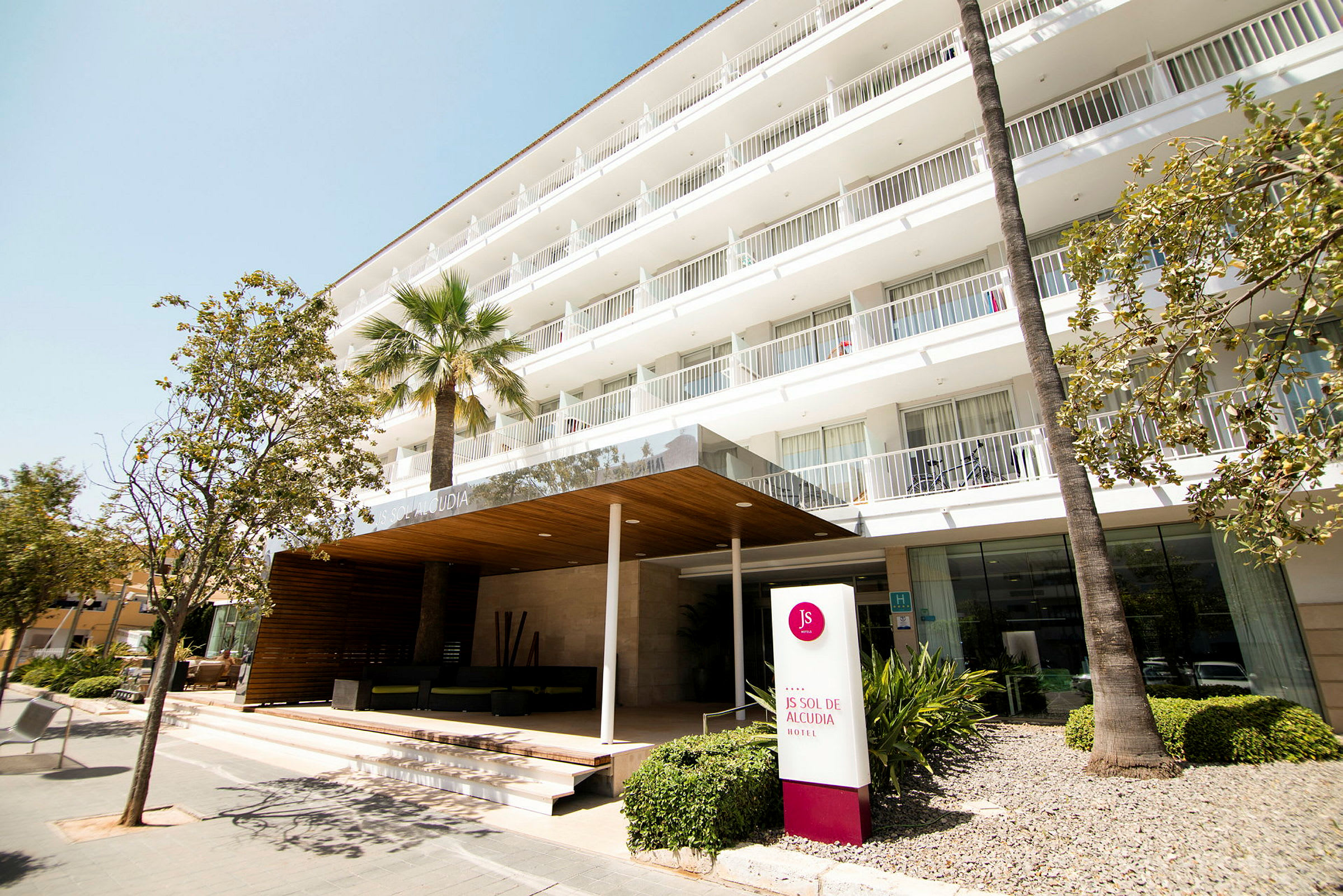 Hotelindgang med skilt der viser 'JS Sol de Alcudia'. (AI-genereret tekst)