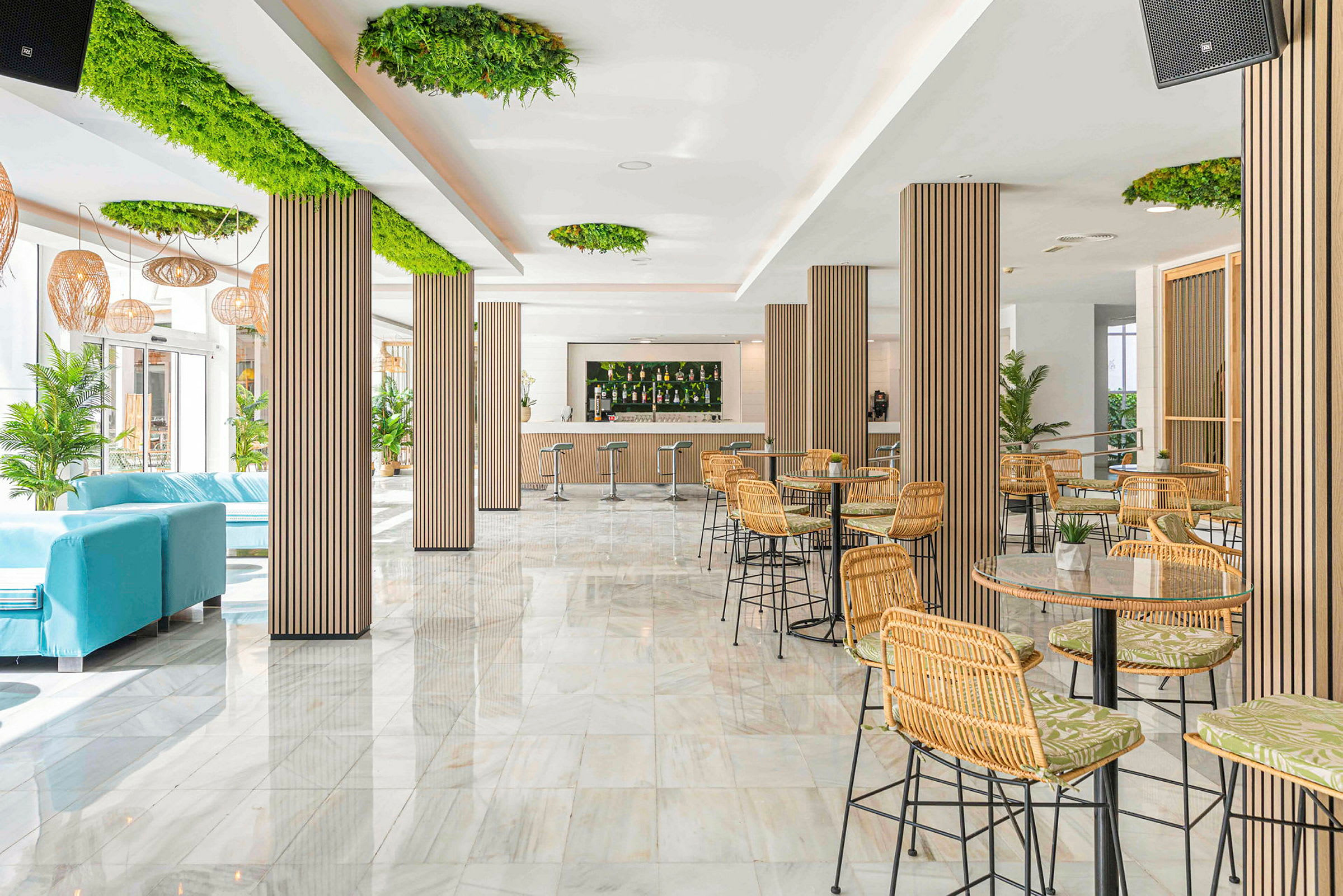 Interiør af en moderne lounge med borde, stole og en bar. (AI-genereret tekst)