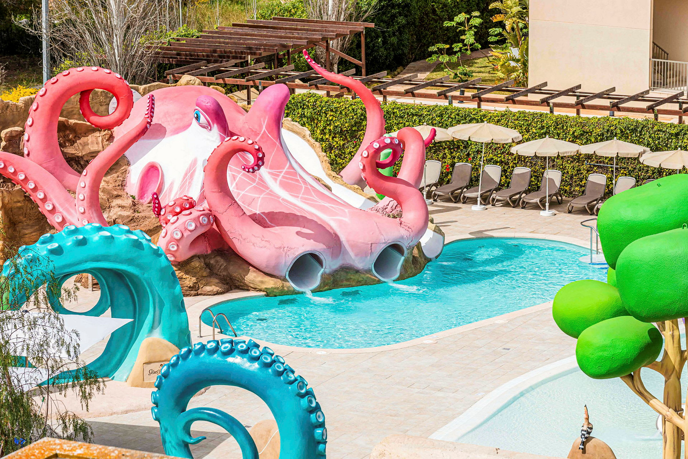 Vandtema med en stor pink blæksprutte ved en pool, omgivet af liggestole og grønne detaljer. (AI-genereret tekst)