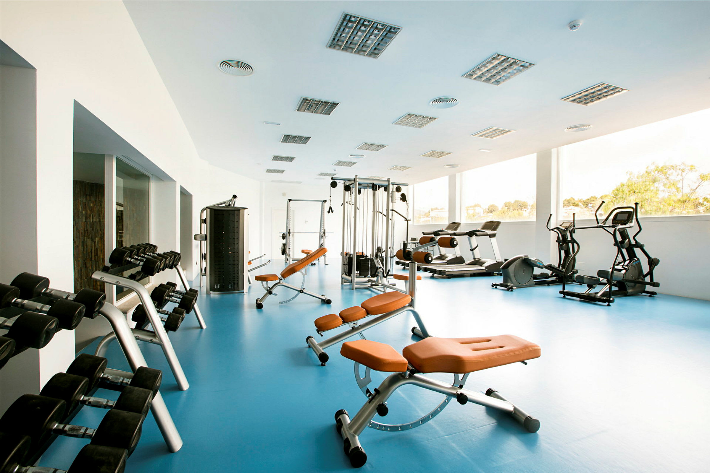 Et fitnesscenter med træningsudstyr såsom bænke, vægte og konditionsmaskiner. (AI-genereret tekst)