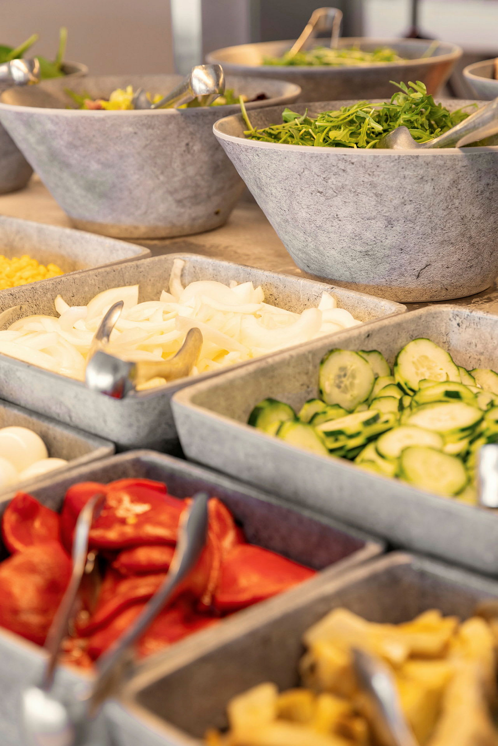 En salatbuffet med forskellige grøntsager og tilbehør i skåle. (AI-genereret tekst)