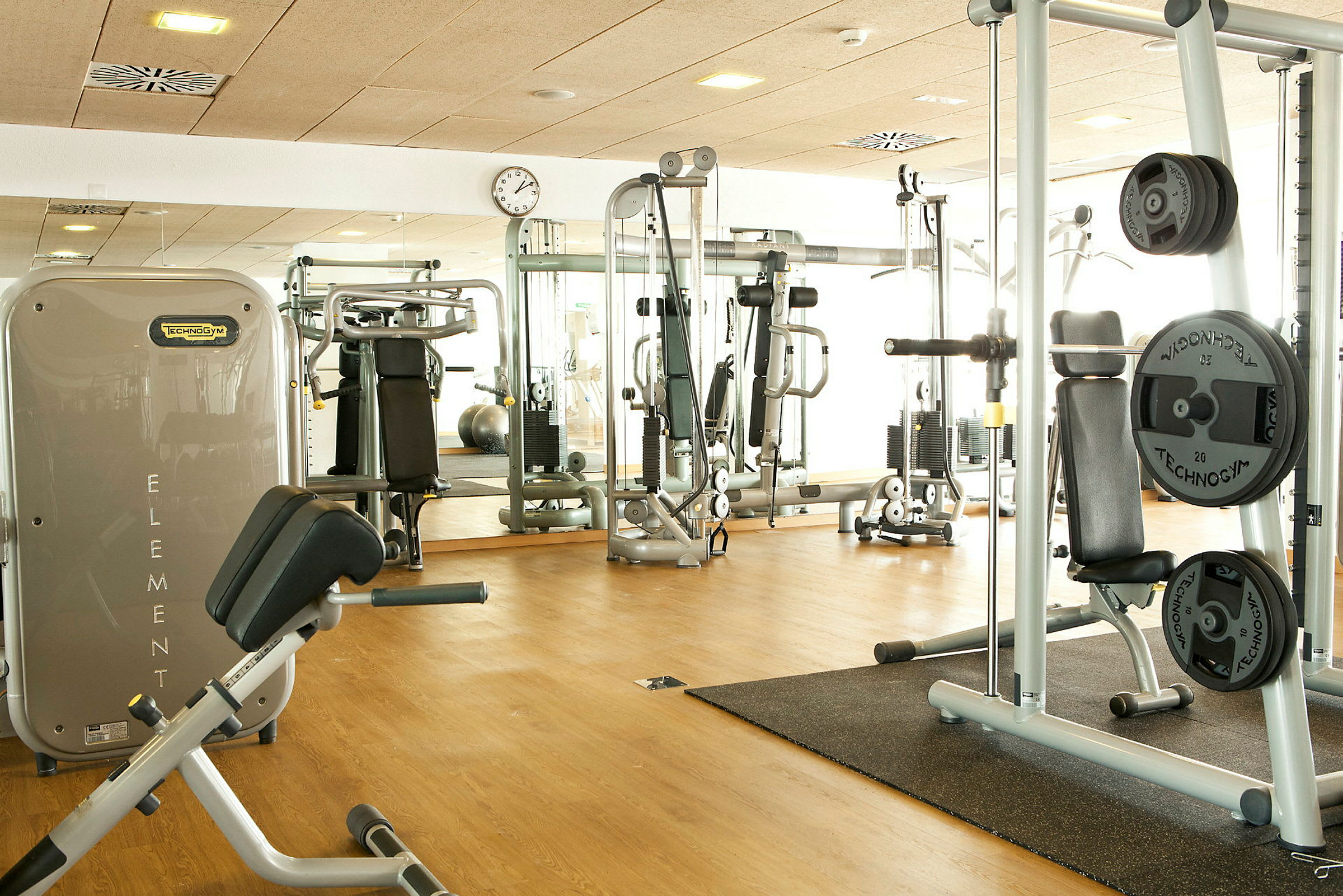 Interiørbillede af et fitnesscenter med træningsmaskiner. (AI-genereret tekst)