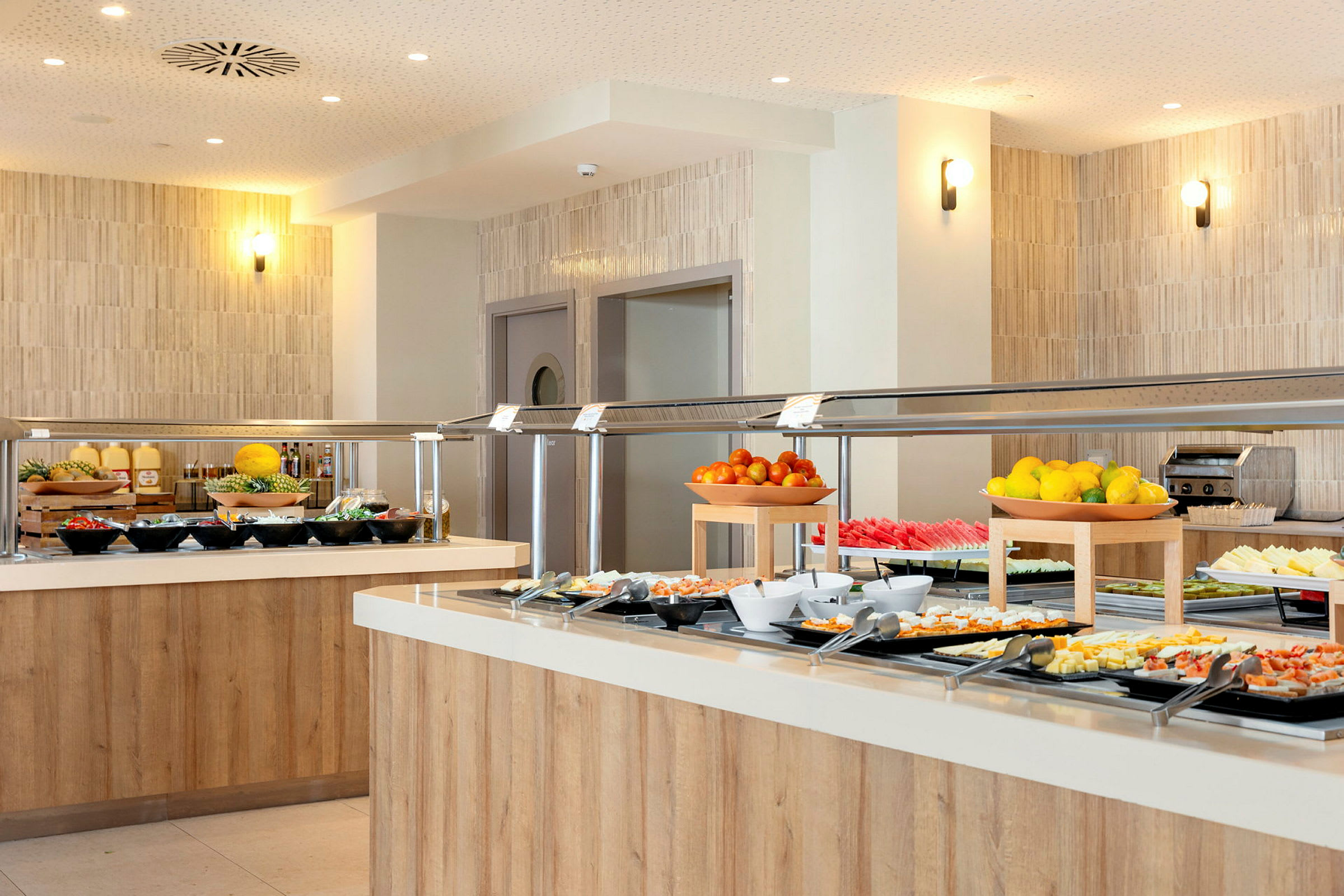 Buffet med frugt og andre retter på en moderne servering. (AI-genereret tekst)