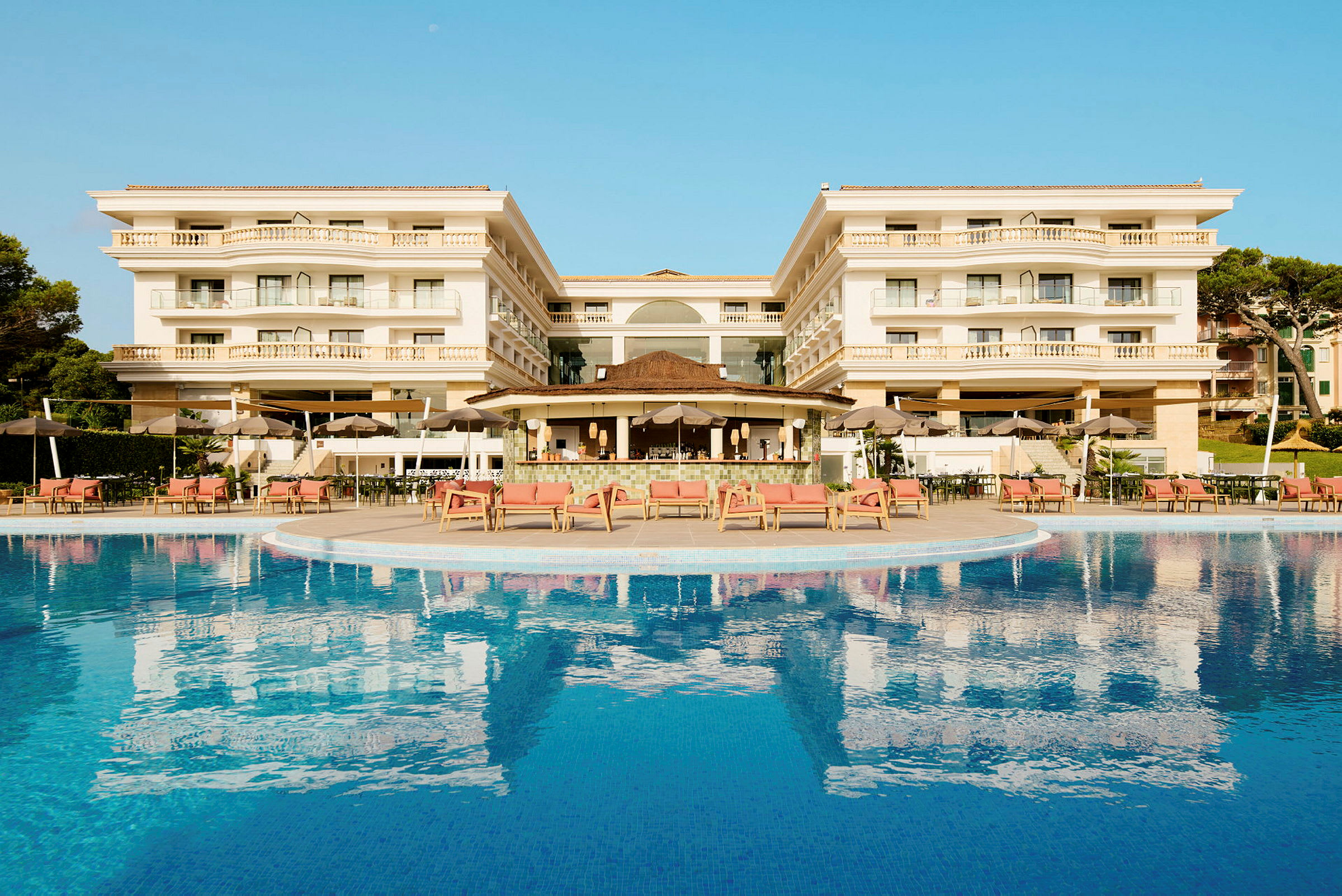 Billede af et hotel med en pool i forgrunden. (AI-genereret tekst)