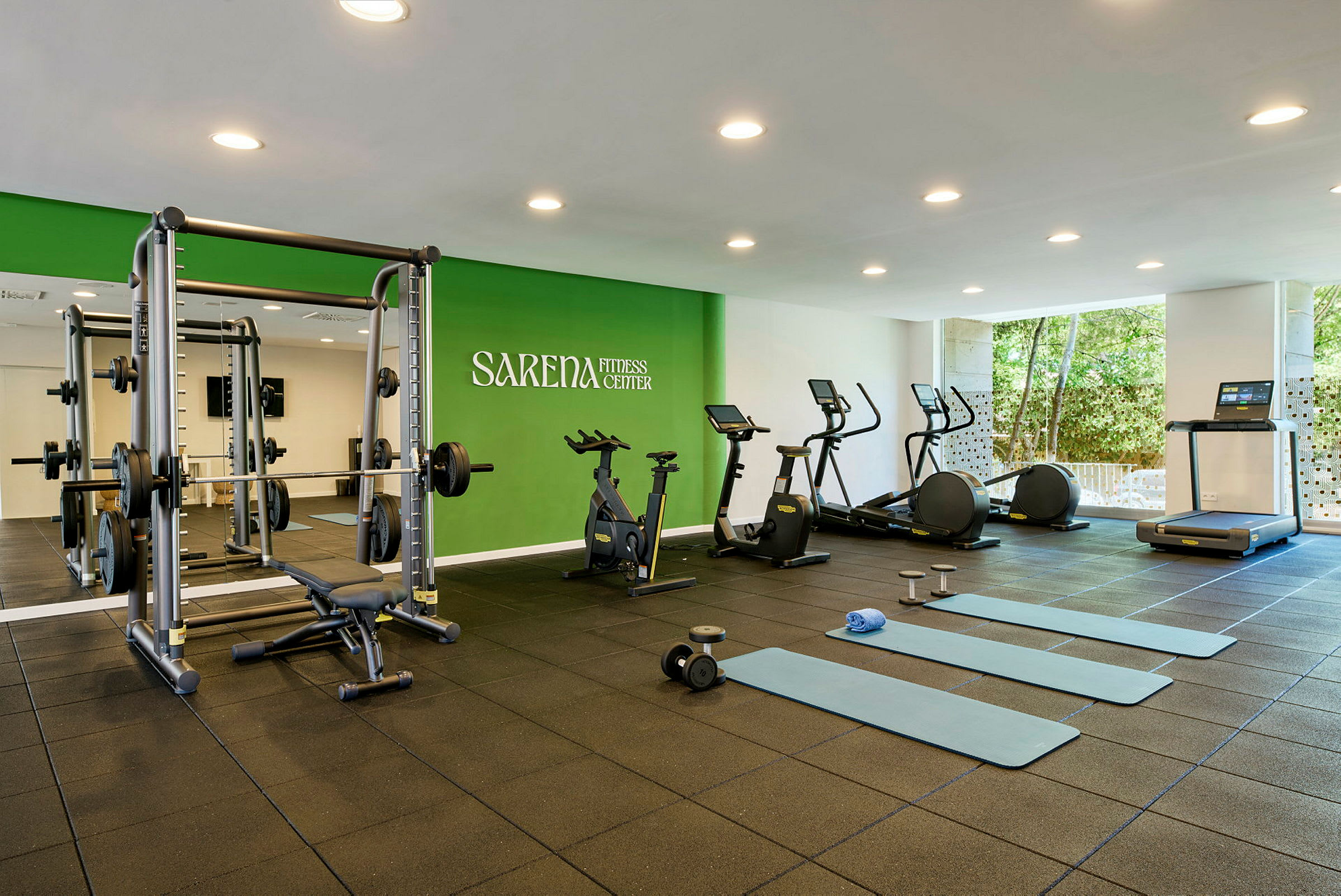 Fitnesscenter med træningsmaskiner og træningsmåtter. (AI-genereret tekst)