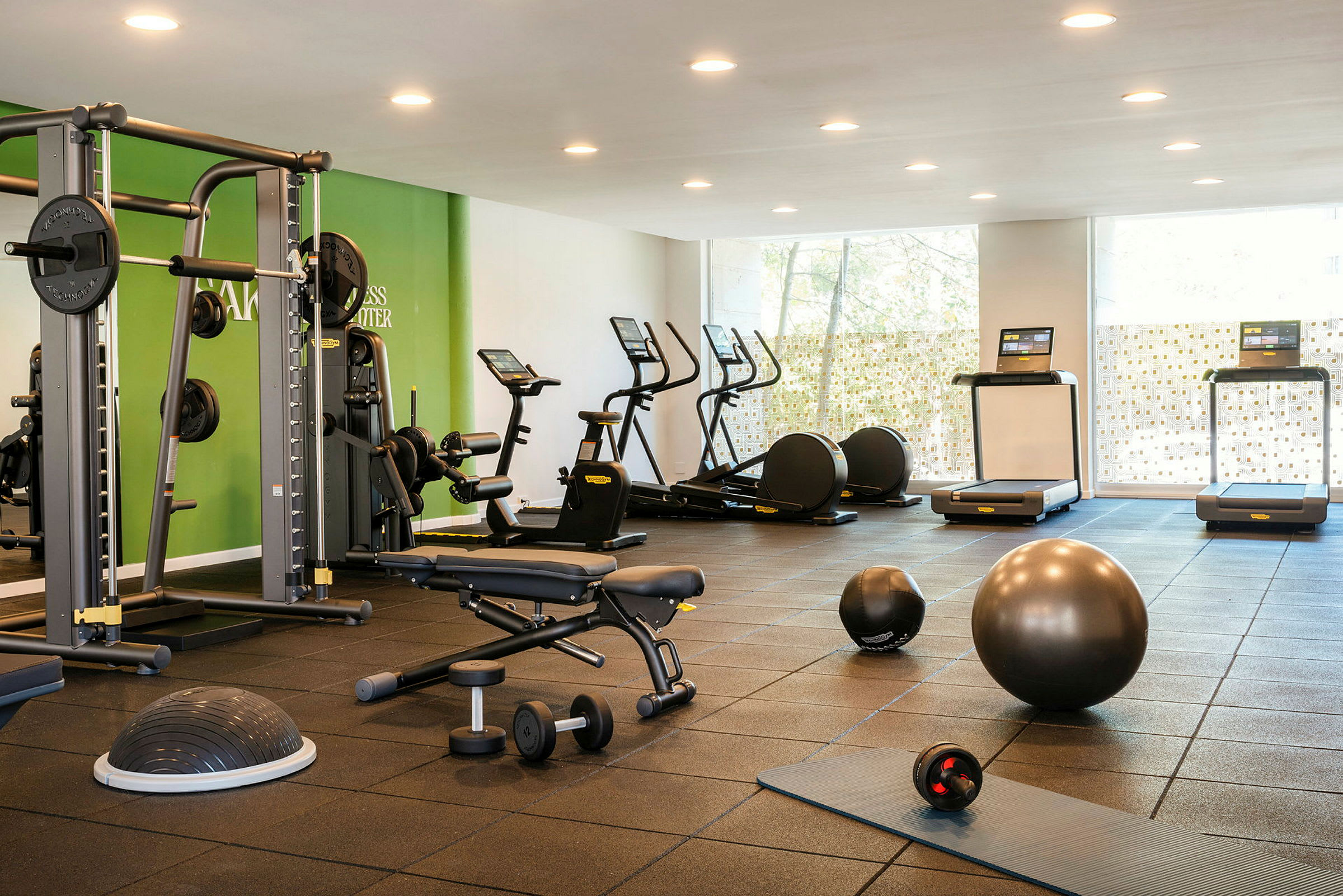 Et fitnesscenter udstyret med moderne træningsmaskiner og redskaber. (AI-genereret tekst)