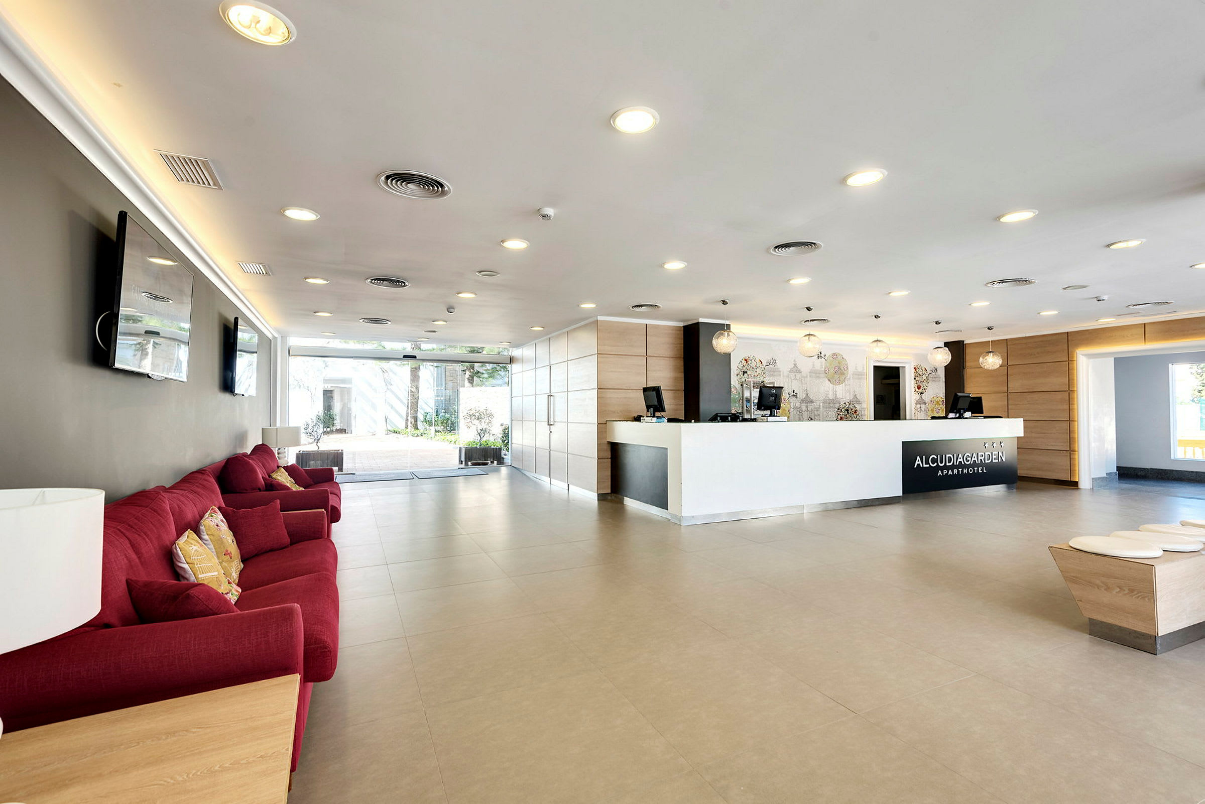 Hotelreception med en hvid modtagelsesdisk, røde sofaer og moderne interiør. (AI-genereret tekst)
