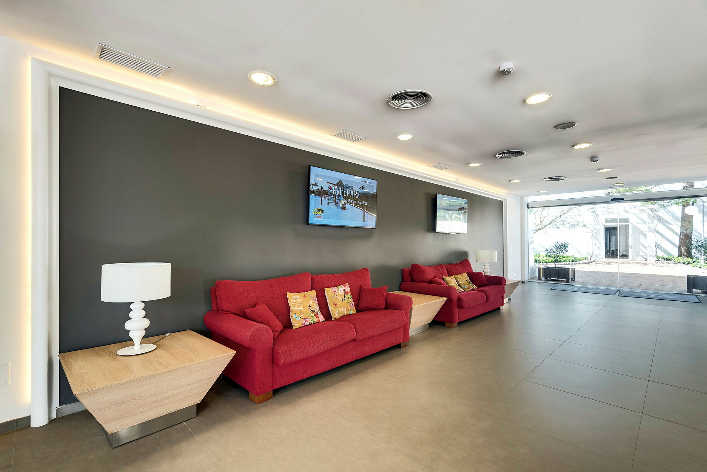 Rød sofa og bord i en moderne indrettet lounge. (AI-genereret tekst)