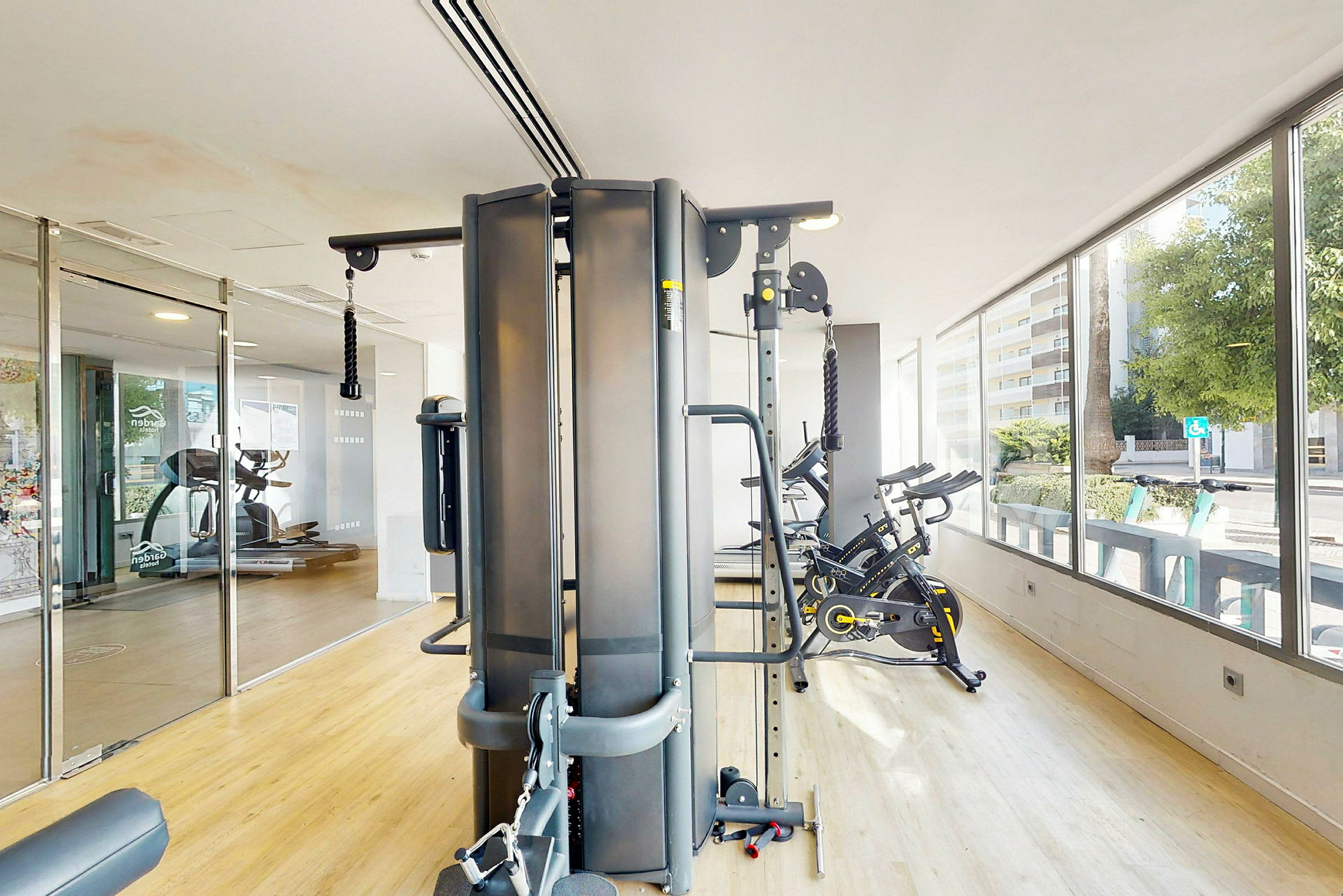 Et fitnesscenter med forskellige træningsmaskiner, herunder motionscykler og en multigym-maskine. (AI-genereret tekst)