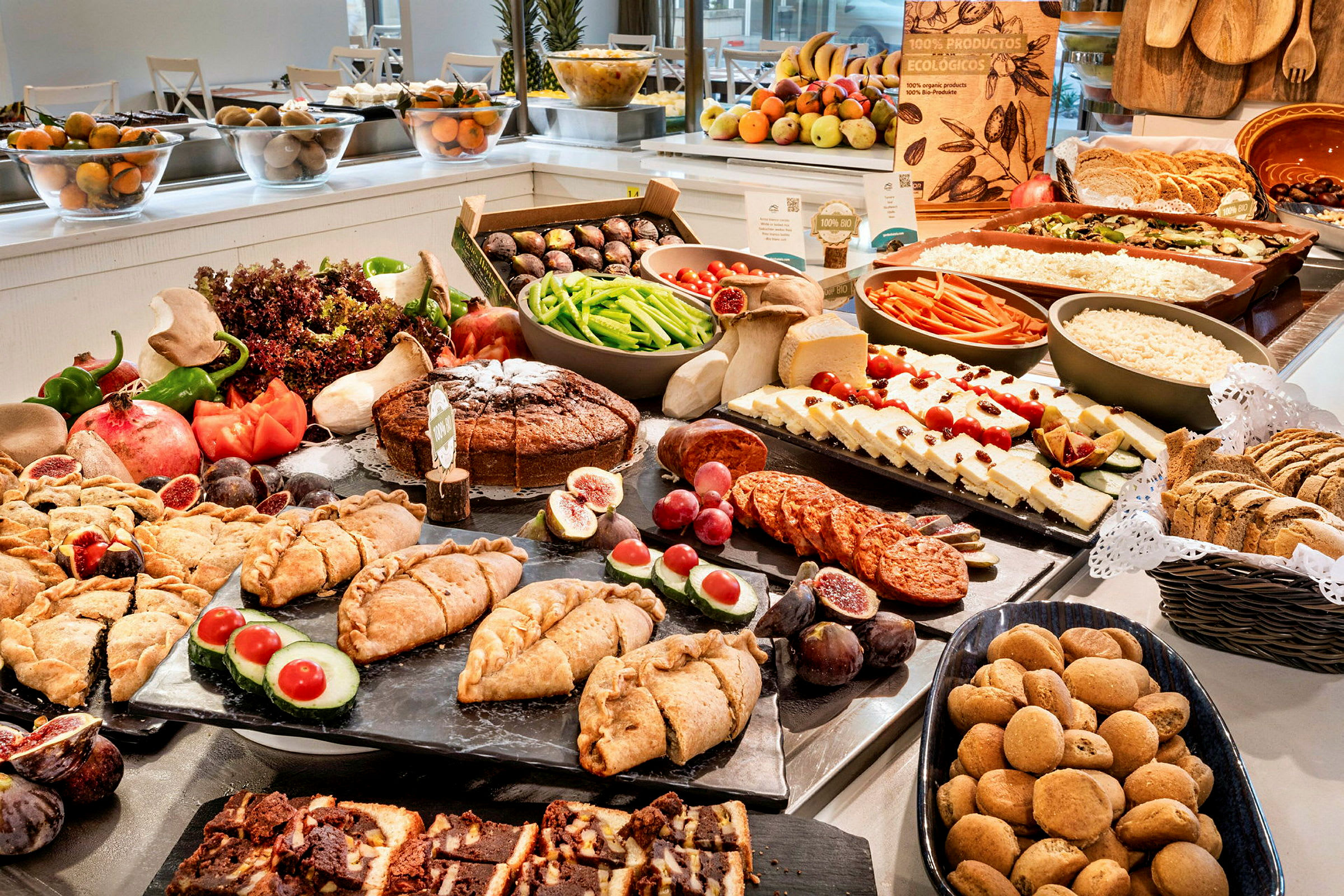 Buffet med forskellige madvarer som grøntsager, brød og desserter. (AI-genereret tekst)