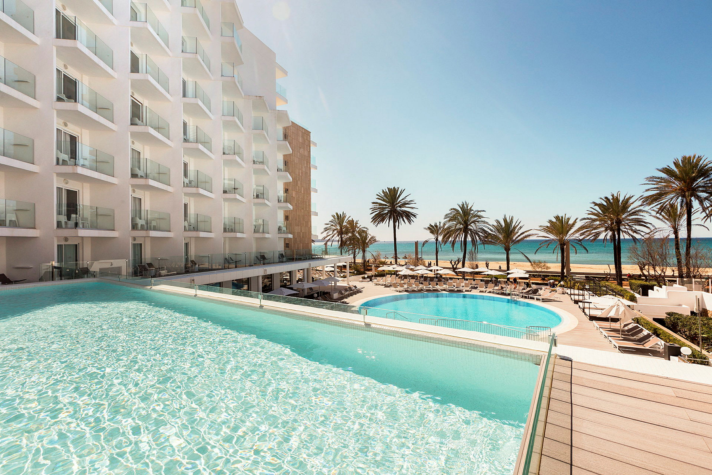 Hotel med pool og udsigt over stranden og havet. (AI-genereret tekst)