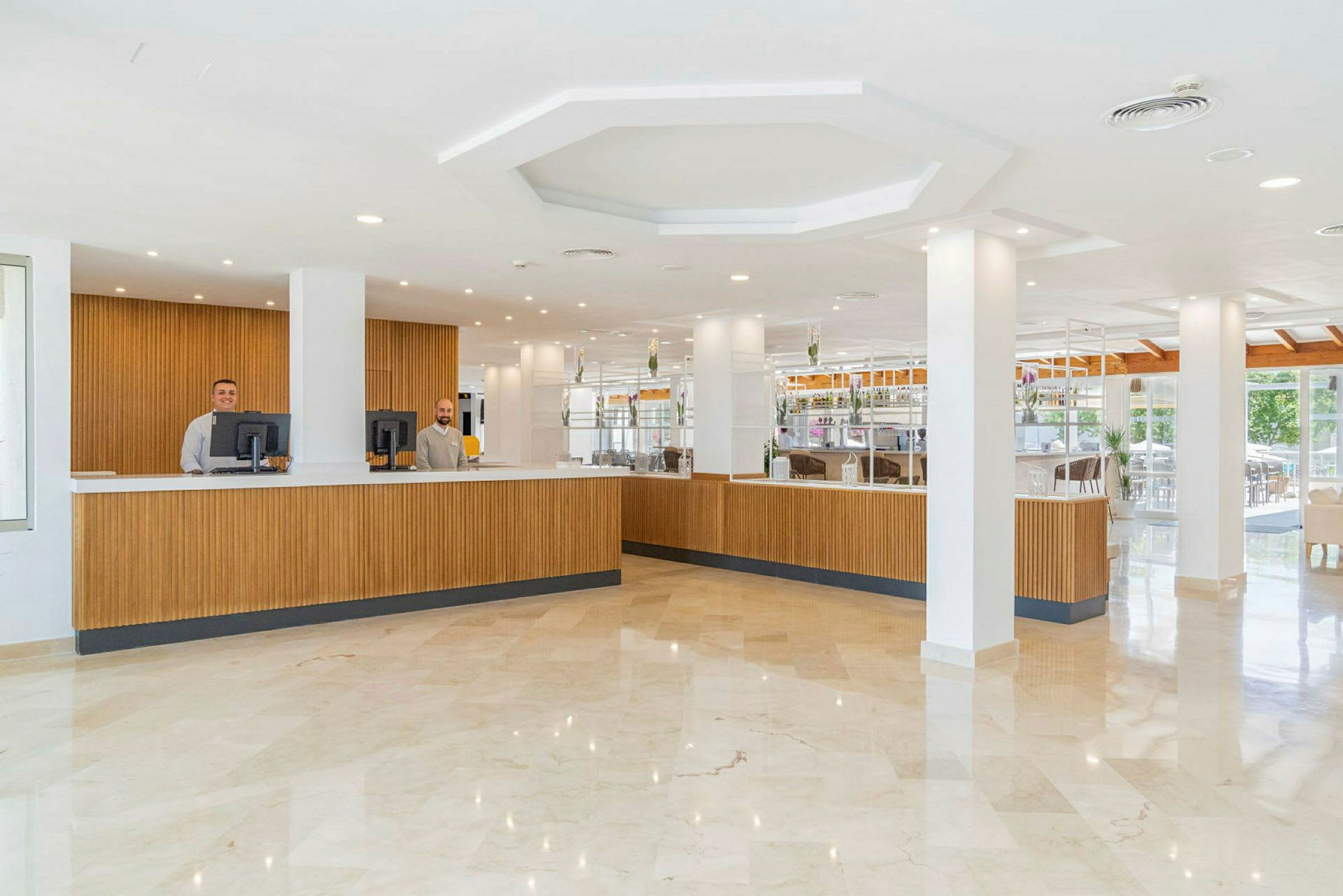 Receptionen og lobbyområdet på et hotel med en lang trædisk og lyse indretningsdetaljer. (AI-genereret tekst)