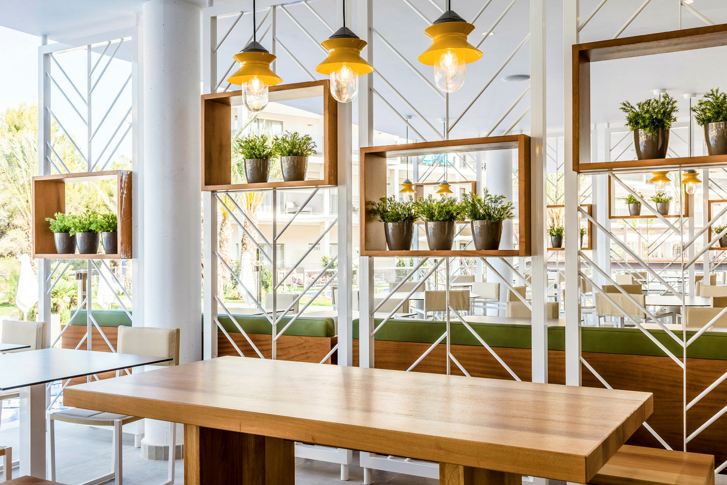 Et lyst og moderne indrettet område med borde og planteudsmykning. (AI-genereret tekst)