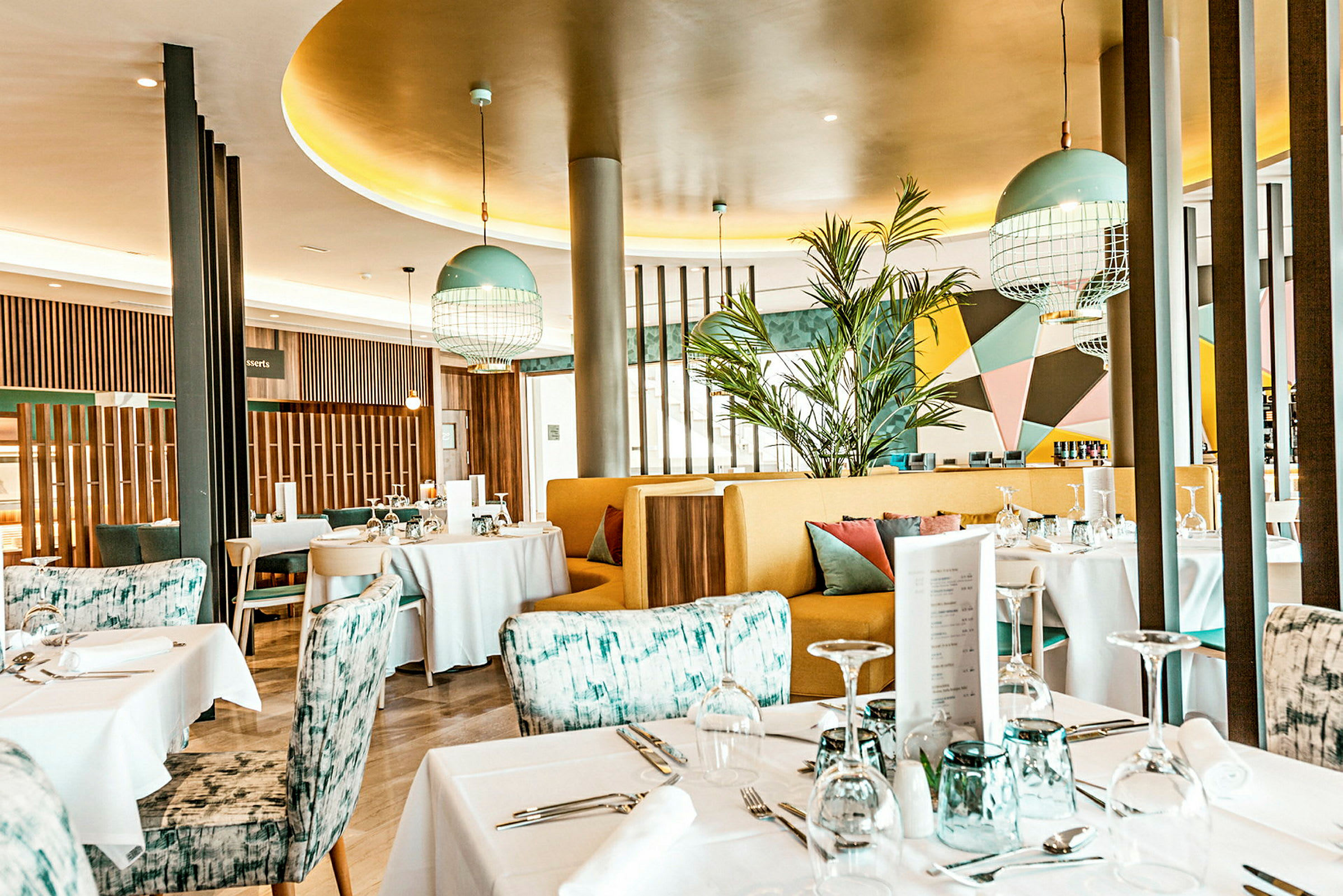 En moderne og farverig restaurant med dækkede borde og stilfuld indretning. (AI-genereret tekst)